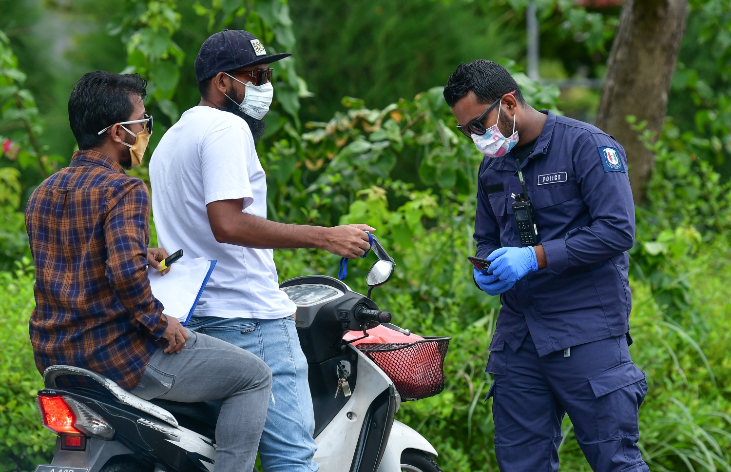 ހުޅުމާލެ: މެއި 21، 2020- ހުޅުމާލެ ލޮކްޑައުންގައި އޮތް އިރު، ސައިކަލެއްގައި ދިޔަ ދެ މީހެއްގެ ލައިސަންސް ފުލުހަކު ޗެކް ކުރަނީ.---ފޮޓޯ: ނިޝާން އަލީ/މިހާރު