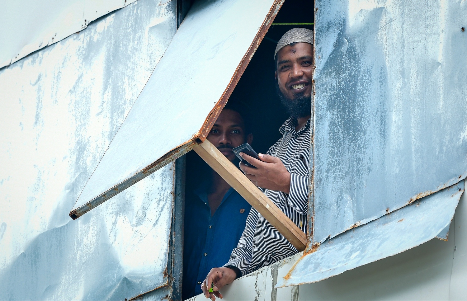 ހުޅުމާލެ: މެއި 21، 2020: ހުޅުމާލެ ލޮކްޑައުން ކޮށްފައިވާއިރު، ދެ ބިދޭސީއަކު ގޭގެ ކުޑަދަޮރުން ކެމެރާ އަށް ބަލަހައްޓައިގެން.---ފޮޓޯ: ނިޝާން އަލީ/މިހާރު