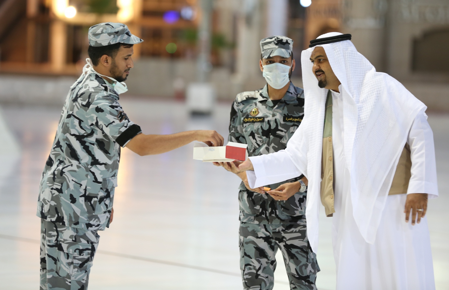 މައްކާ - މެއި 24، 2020: މައްކާގެ މާތްވެގެންވާ ހަރަމްފުޅުގައި މިއަދު އީދު ނަމާދުގެ ކުރިން ސަލާމަތީ އޮފިޝަލަކަށް ހަދިޔާ ދެނީ. --ފޮޓޯ:އޭއެފްޕީ