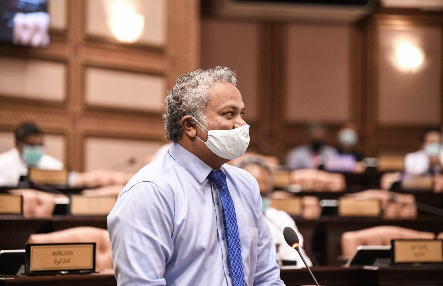 މާލެ: މެއި 26، 2020: މަޖިލިސް މެމްބަރުން މިއަދުގެ ޖަލްސާގައި މެމްބަރަކު ވާހަކަ ދައްކަވަނީ: މެމްބަރުން ތިއްބެވީ މާސްކު އަޅުއްވައިގެން، ހާއްސަ އިންތިޒާމެއްގެ ތެރެއިން ދުރުދުރުގައި-- ފޮޓޯ: މަޖިލިސް