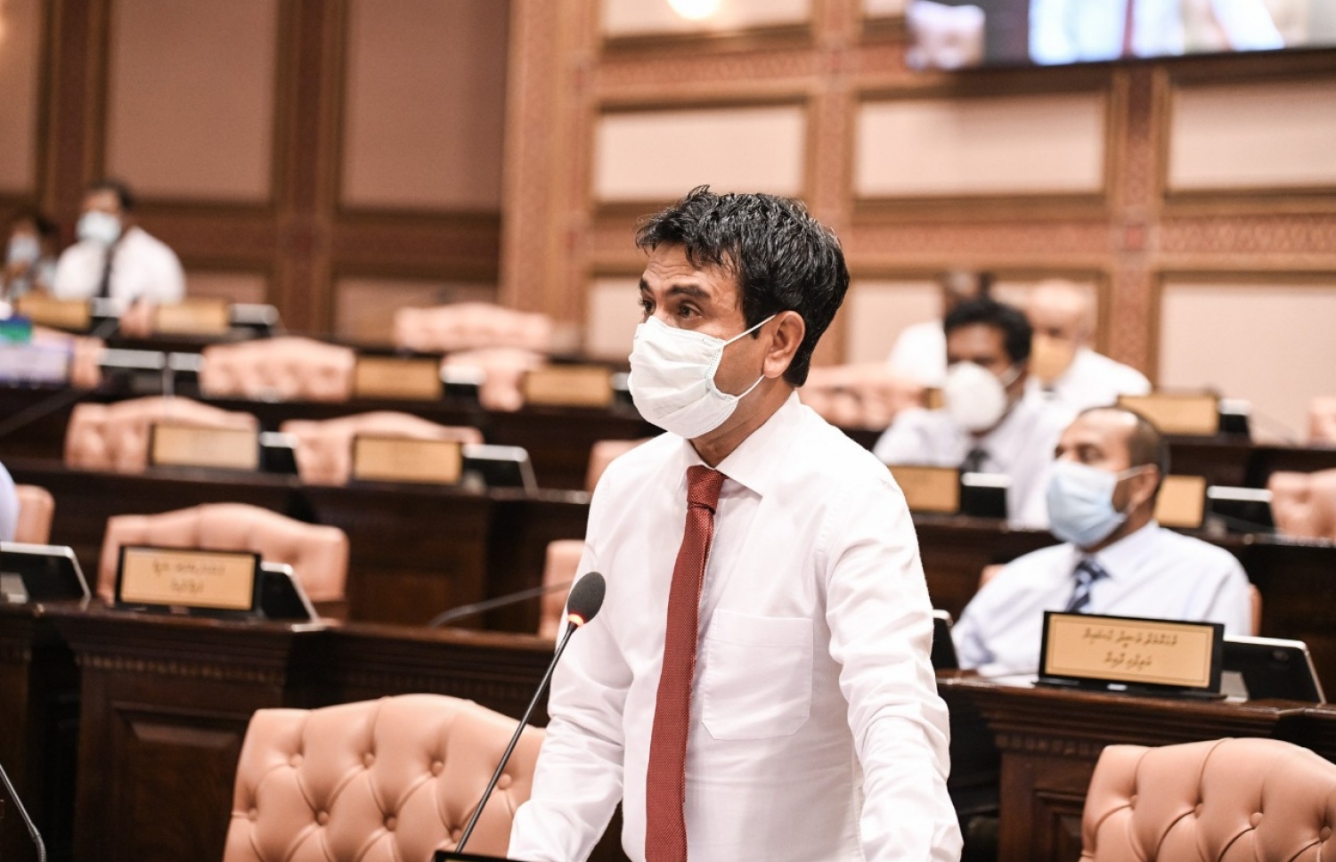 މާލެ: މެއި 26، 2020: މަޖިލިސް މެމްބަރުން މިއަދުގެ ޖަލްސާގައި ހޯރފުށި ދާއިރާގެ މެމްބަރު އަހުމަދު ސަލީމް ވާހަކަ ދައްކަވަނީ: މެމްބަރުން ތިއްބެވީ މާސްކު އަޅުއްވައިގެން، ހާއްސަ އިންތިޒާމެއްގެ ތެރެއިން ދުރުދުރުގައި-- ފޮޓޯ: މަޖިލިސް