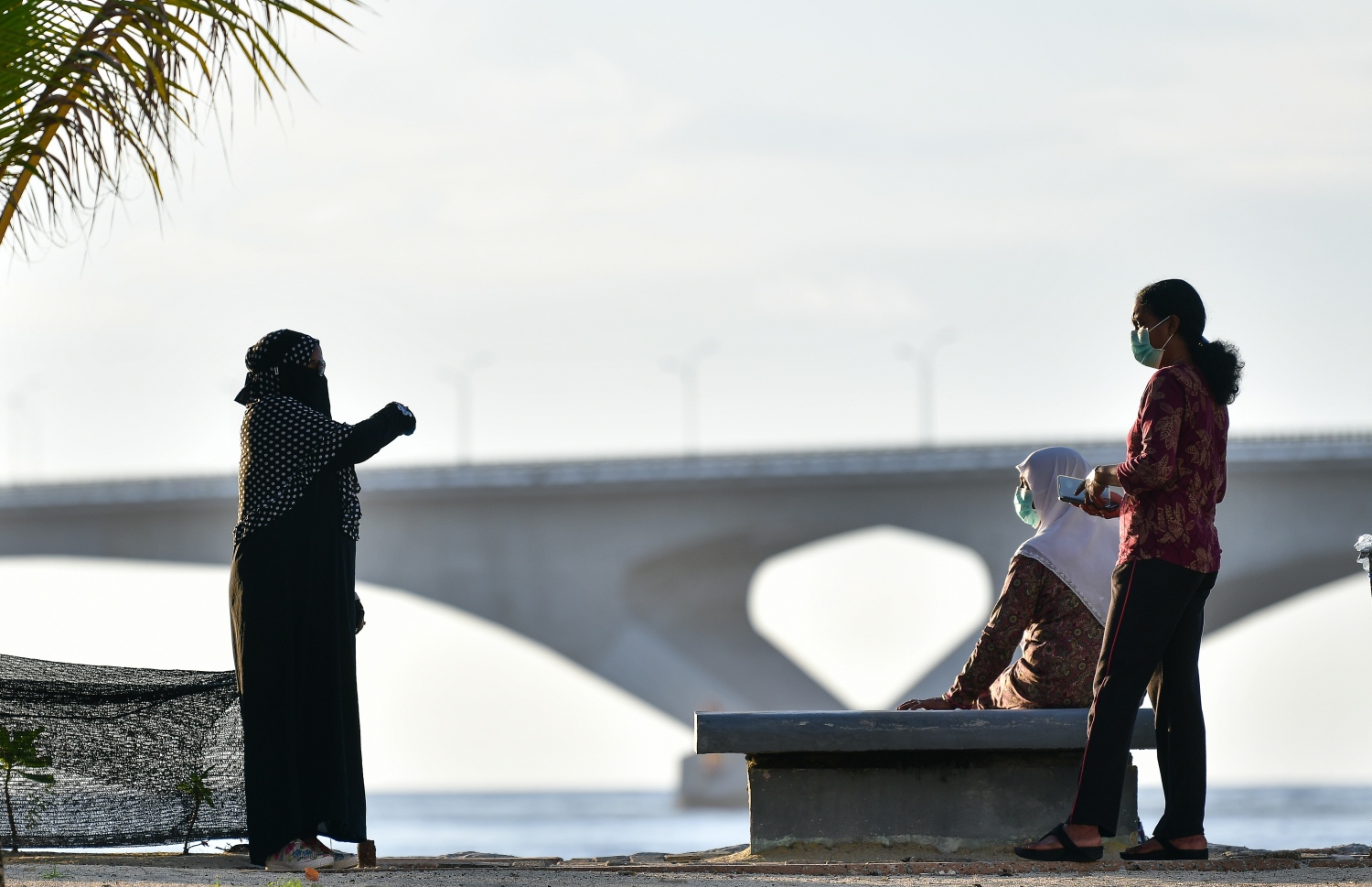 ބްރިޖް ކައިރީގައި ބަޔަކު ވާހަކަ ދައްކާލަން މަޑުކޮށްލައިގެން: ހާލުގައި ޖެހޭ މީހުންގެ އަދަދު ދަނީ އިތުރުވަމުން--. ފޮޓޯ: ނިޝާން އަލީ/މިހާރު