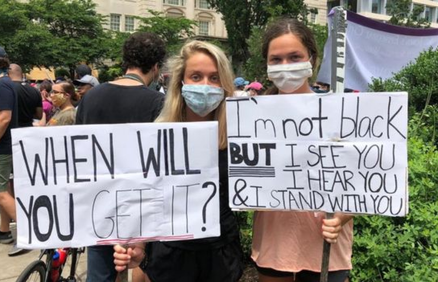 ވައިޓް ހައުސްގެ ބޭރުގައި މުޒާހަރާ ކުރާ ދެ މީހަކު ބޯޑެއް ހިފައިގެން. --ފޮޓޯ:ގެޓީ އިމޭޖަސް