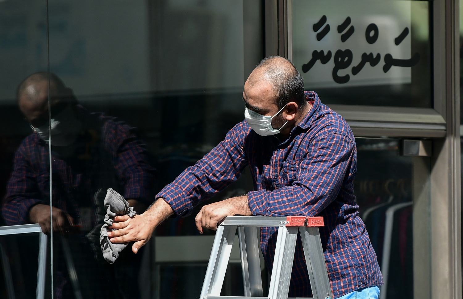 މާލެ: ޖޫން 15، 2020: ދެ މަހުގެ ބަންދަކަށް ފަހު، މަޖީދީމަގުގައި ހުޅުވާފައި ހުރި ފިހާރައެއްގެ ބޭރު ބިއްލޫރިގަނޑު ސާފުކުރަނީ.-- ފޮޓޯ: ނިޝާން އަލީ /މިހާރު