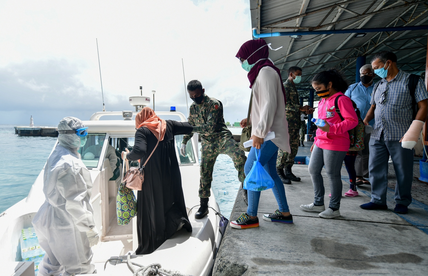 މާލެ: ޖޫން 15، 2020: ދެ މަހުގެ ބަންދަކަށް ފަހު، މާލެއިން ރަށް ރަށަށް ދިއުމަށް ހުޅުމާލެ ޓާމިނަލުގައި ތިބި ބަޔަކު އެމްއެންޑީއެފްގެ އެހީތެރިކަމާއެކު ލޯންޗަށް އަރަނީ-- ފޮޓޯ: ނިޝާން އަލީ /މިހާރު