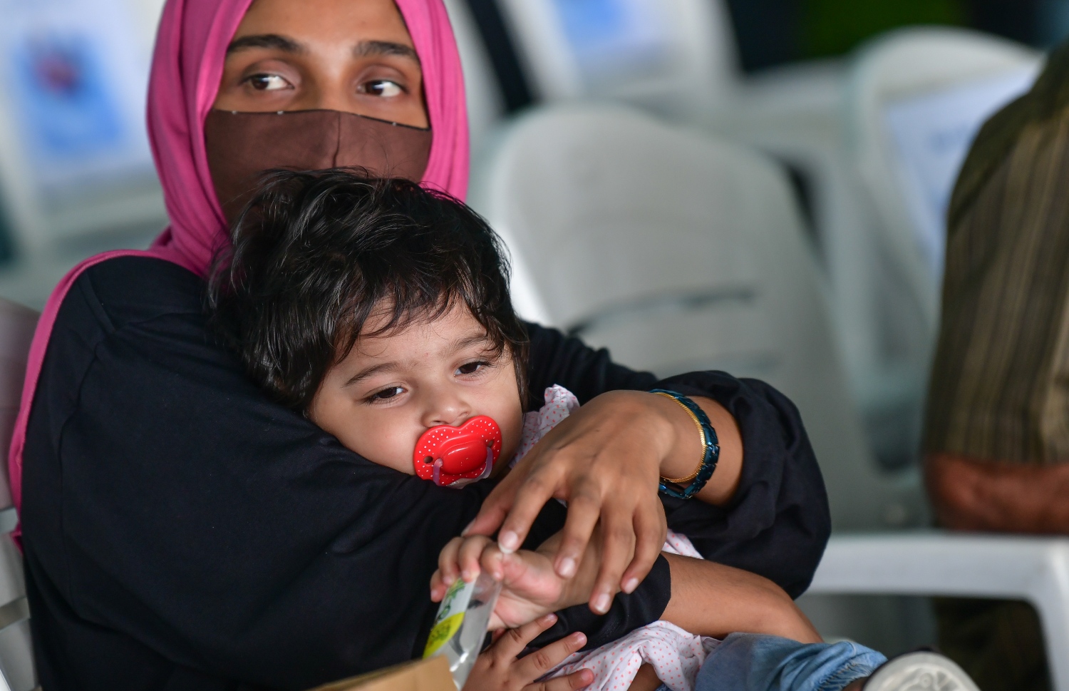 މާލެ: ޖޫން 15، 2020: ދެ މަހުގެ ބަންދަކަށް ފަހު، މާލެއިން ރަށް ރަށަށް ދިއުމަށް ހުޅުމާލެ ޓާމިނަލުގައި އަންހެނަކު ކުޑަކުއްޖަކު ގޮވައިގެން.-- ފޮޓޯ: ނިޝާން އަލީ /މިހާރު