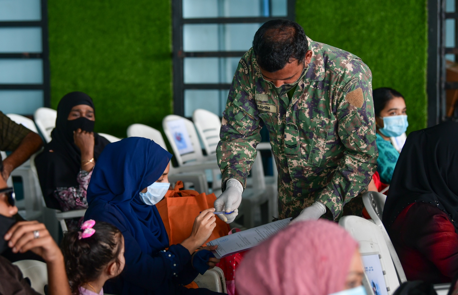 މާލެ: ޖޫން 15، 2020: ދެ މަހުގެ ބަންދަކަށް ފަހު، މާލެއިން ރަށް ރަށަށް ދިއުމަށް ހުޅުމާލެ ޓާމިނަލުގައި ތިބި ބަޔަކު އިގުރާރުގައި ސޮއި ކުރަނީ.-- ފޮޓޯ: ނިޝާން އަލީ /މިހާރު