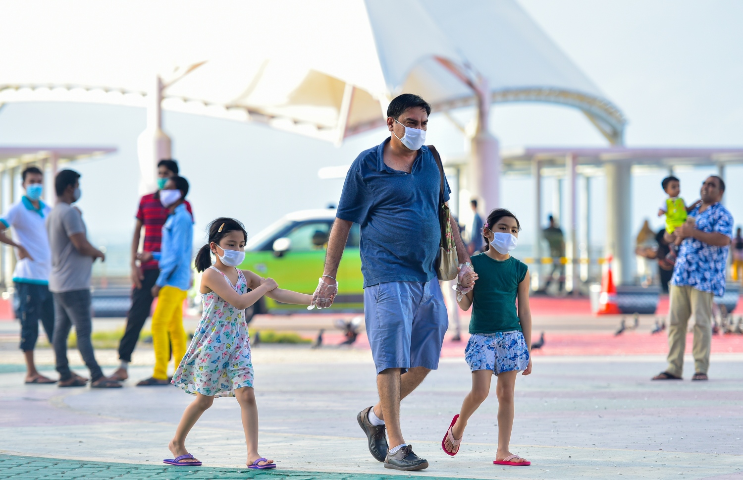 މާލެ: ޖޫން 15، 2020- ކޮވިޑް-19 އިން ރައްކާތެރިވުމަށް މާލެ ސަރަހައްދުގައި އިއުލާން ކޮށްފައިވާ ލޮކްޑައުން އަށް ދިން ލުޔާ އެކު، ޖުމްހޫރީ މައިދާން ސަރަަހައްދުގައި ކުޑަ ދެ ކުއްޖަކު ގޮވައިގެން މީހަކު ހިނގާފައި ދަނީ.---ފޮޓޯ: އަހުމަދު އަވްޝަން/މިހާރު