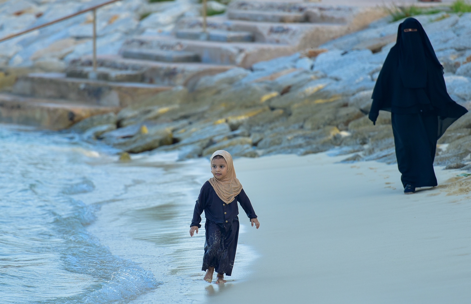 މާލެ: ޖޫން 15، 2020- ހެންވޭރު އާޓިފިޝަލް ބީޗް ސަރަހައްދުގެ މޫދަށް އެރޭ ކުޑަކުއްޖެއްގެ ފަހަތުން އެ ކުއްޖާގެ ބެލެނިވެރިޔާ ދަނީ.---ފޮޓޯ: އަހުމަދު އަވްޝަން/މިހާރު