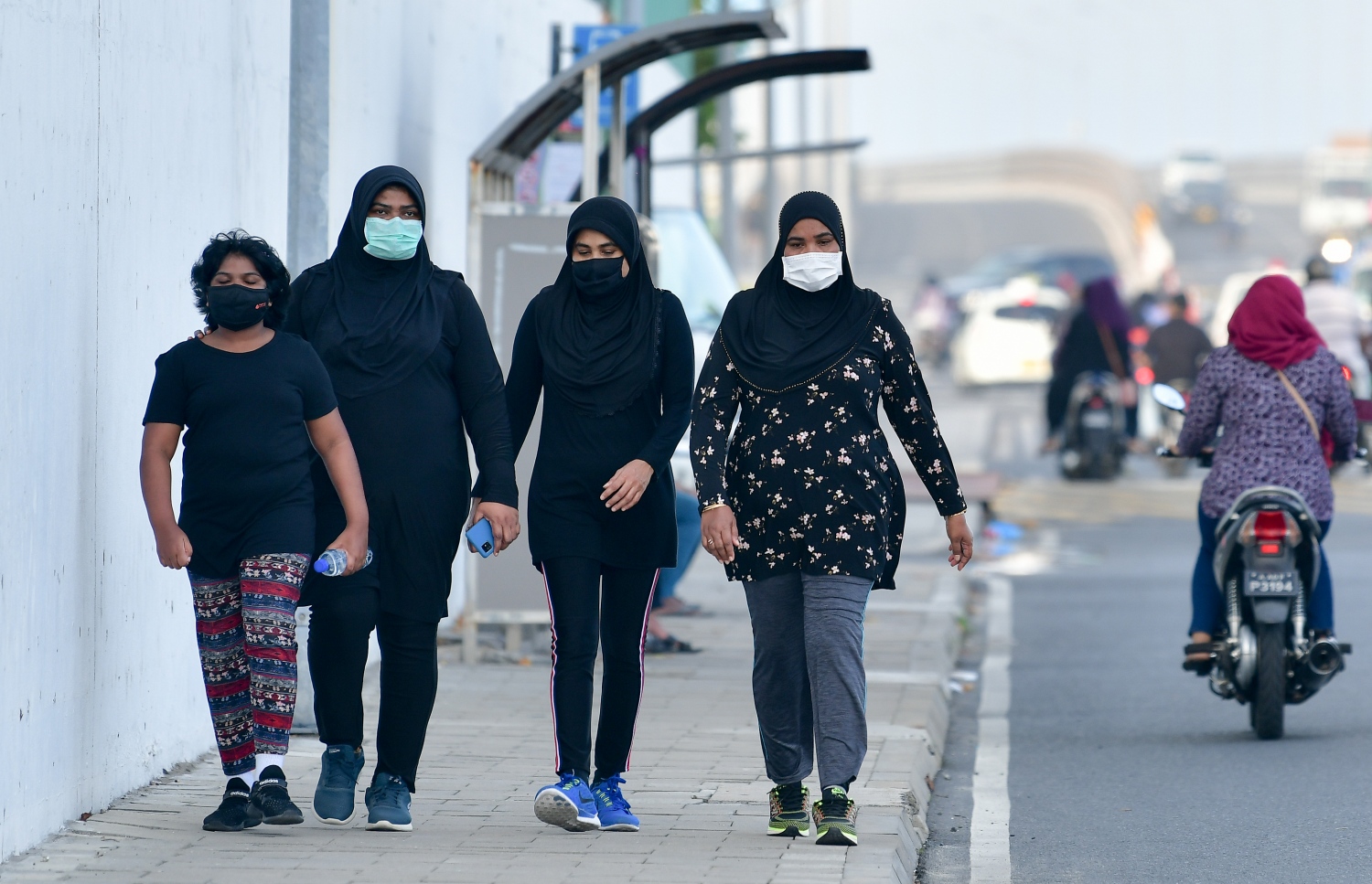 މާލެ: ޖޫން 21، 2020: މާލެ ސަރަހައްދަށް އިއުލާން ކޮށްފައިވާ ލޮކްޑައުން އަށް ލުޔެއް ދިނުމާއެކު، އަންހެނުންތަކެއް މާސްކު އަޅައިގެން ހުރި ނަމަވެސް އެއްވެސް ގައިދުރު ކުރުމެއް ނެތި މަގުމަތީ ހިނގާފައި ދަނީ.-- ފޮޓޯ: ނިޝާން އަލީ /މިހާރު