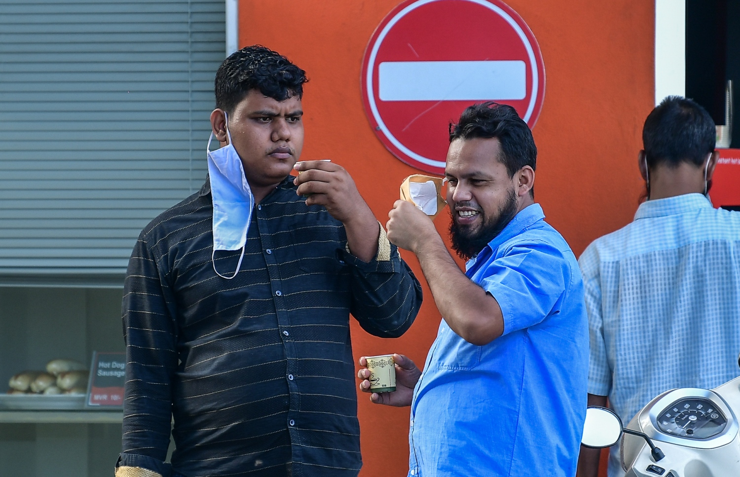 މާލެ: ޖޫން 21، 2020: މާލެ ސަރަހައްދަށް އިއުލާން ކޮށްފައިވާ ލޮކްޑައުން އަށް ލުޔެއް ދިނުމާއެކު، ދެމީހަކު މަގުމަތީގައި ކޮފީއެއް ބޯން މަޑުކޮށްލައިގެން.-- ފޮޓޯ: ނިޝާން އަލީ /މިހާރު