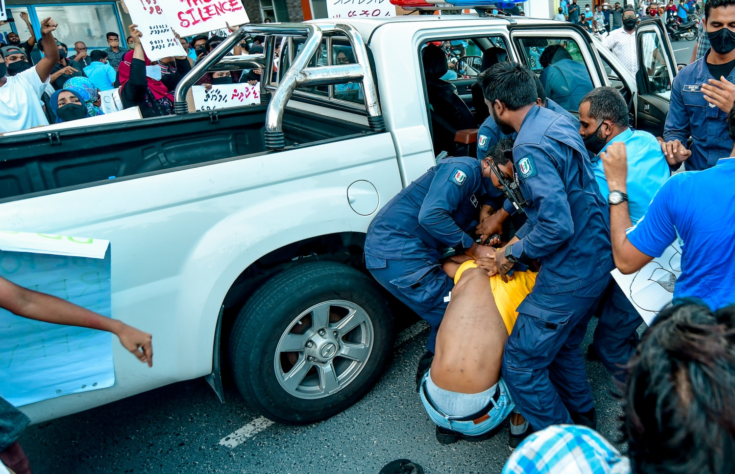 މިއަދު ކުރި މުޒާހަރާގައި މީހަކު ފުލުހުންގެ ވެހިކަލް އަށް އަރުވަނީ -- ފޮޓޯ: ނިޝާން އަލީ/ މިހާރު