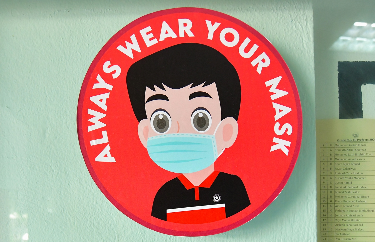 ސްކޫލްގަ އާއި ބޭރުތެރޭގައި މި ދުވަސްވަރު އުޅޭއިރު، ކޮވިޑް-19 އިން ރައްކާތެރިވުމަށް އަބަދުވެސް މާސްކް އެޅުމަށް ހަނދާކޮށް ދިނުމުގެ ގޮތުން އިސްކަންދަރު ސްކޫލްގެ ކްލާސްރޫމެއްގެ ބޭރުގައި ސްޓިކާއެއް ތައްކޮށްފައި.---ފޮޓޯ: އަހުމަދު އަވްޝަން/މިހާރު