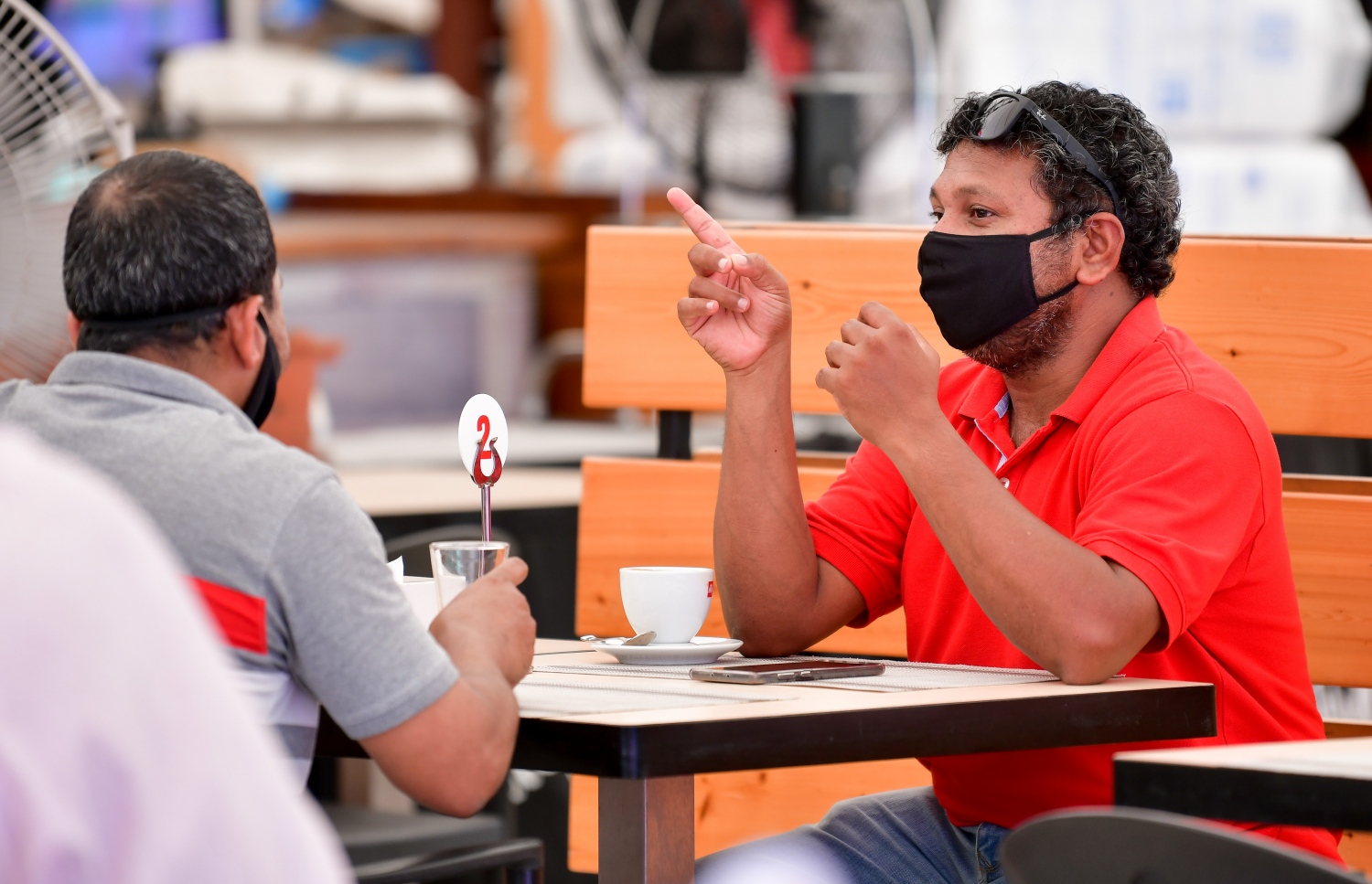 މާލެ: ޖުލައި 1، 2020: ކޮވިޑް-19 އާ ގުޅިގެން އެޅި ރައްކާތެރިކަމުގެ ފިޔަވަޅުތަކުގެ ތެރޭގައި ކެއުންބުއިމުގެ ހިދުމަތް ދޭ ތަންތަނަށް މީހުން ވަނުން މަނާކުރިތާ ތިން މަހަށް ވުރެ ގިނަ ދުވަހަށްފަހު، މާލެ އާއި ހުޅުމާލެ އާއި ވިލިމާލޭގައި، އަލުން އާންމުންނަށް ހޮޓާ/ރެސްޓޯރެންޓް/ކެފޭތައް ހުޅުވާލުމާއެކު ފުޑްކޯޓުގައި ހުރި ކެފޭ އެއްގައި ބަޔަކު ސައި ބޮނީ.-- ފޮޓޯ: ނިޝާން އަލީ /މިހާރު