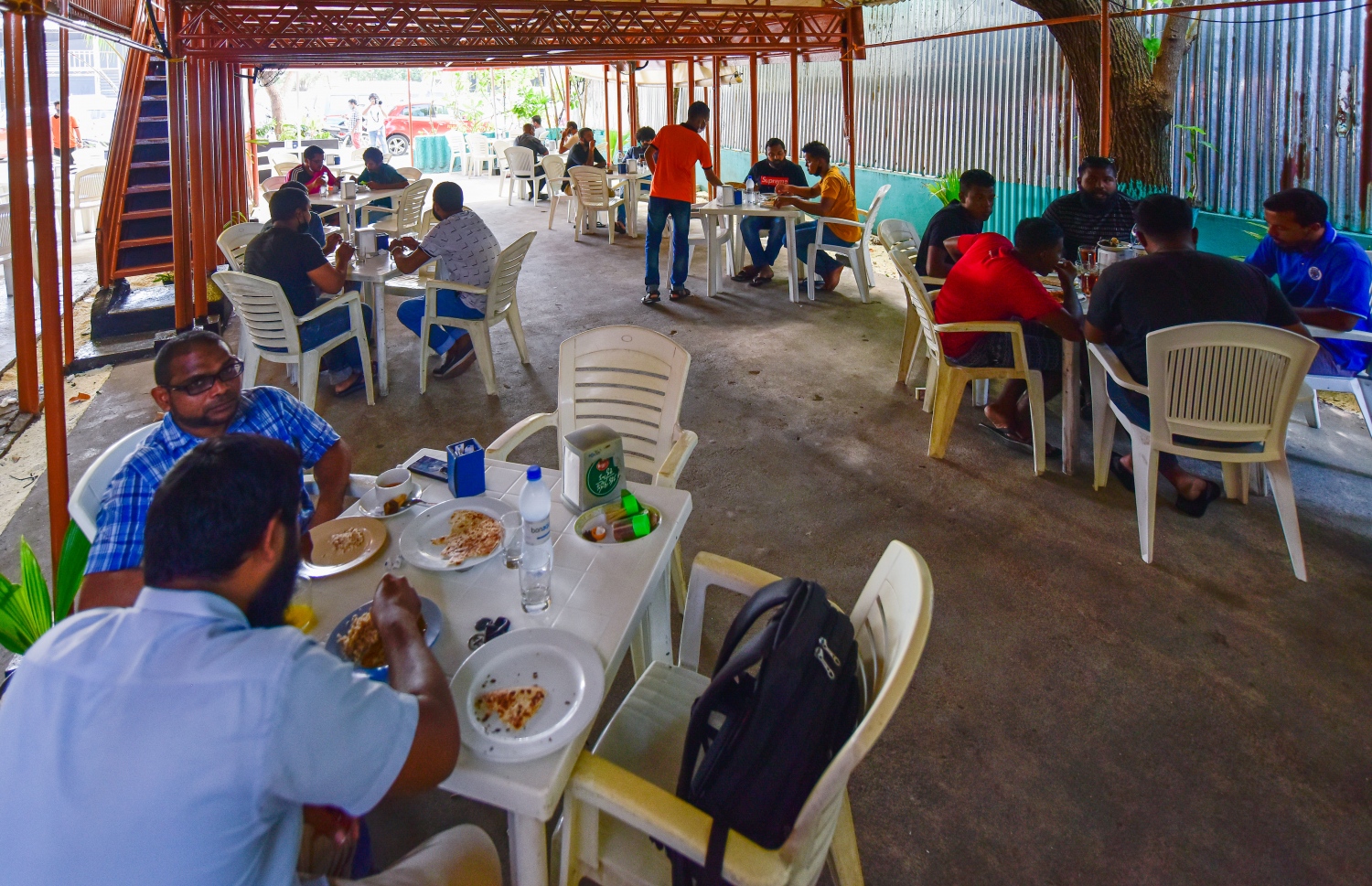 މާލެ: ޖުލައި 1، 2020: ކޮވިޑް-19 އާ ގުޅިގެން އެޅި ރައްކާތެރިކަމުގެ ފިޔަވަޅުތަކުގެ ތެރޭގައި ކެއުންބުއިމުގެ ހިދުމަތް ދޭ ތަންތަނަށް މީހުން ވަނުން މަނާކުރިތާ ތިން މަހަށް ވުރެ ގިނަ ދުވަހަށްފަހު، މާލެ އާއި ހުޅުމާލެ އާއި ވިލިމާލޭގައި، އަލުން އާންމުންނަށް ހޮޓާ/ރެސްޓޯރެންޓް/ކެފޭތައް ހުޅުވާލުމާއެކު ކާނިވަލުގައި ހުރި ކެފޭ އެއްގައި ބަޔަކު ސައި ބޮނީ.-- ފޮޓޯ: އަހުމަދު އަވްޝަން /މިހާރު