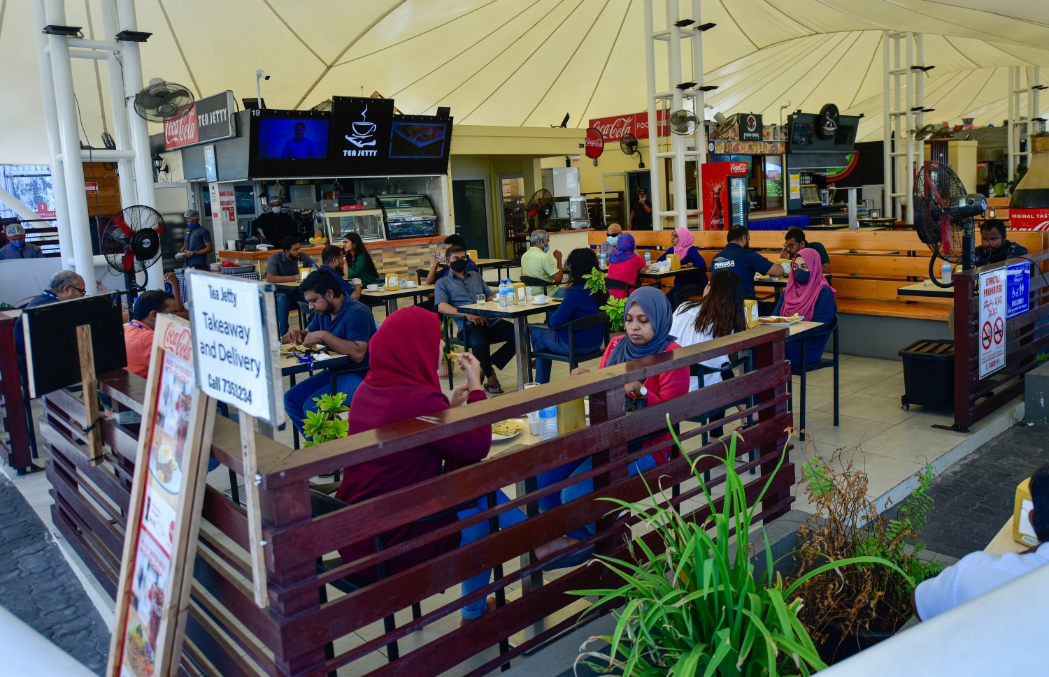 މާލެ: ޖުލައި 1، 2020: ކޮވިޑް-19 އާ ގުޅިގެން އެޅި ރައްކާތެރިކަމުގެ ފިޔަވަޅުތަކުގެ ތެރޭގައި ކެއުންބުއިމުގެ ހިދުމަތް ދޭ ތަންތަނަށް މީހުން ވަނުން މަނާކުރިތާ ތިން މަހަށް ވުރެ ގިނަ ދުވަހަށްފަހު، މާލެ އާއި ހުޅުމާލެ އާއި ވިލިމާލޭގައި، އަލުން އާންމުންނަށް ހޮޓާ/ރެސްޓޯރެންޓް/ކެފޭތައް ހުޅުވާލުމާއެކު ބަޔަކު ފުޑް ކޯޓުގައި ކޮފީ ބޮނީ.-- ފޮޓޯ: އަހުމަދު އަވްޝަން /މިހާރު