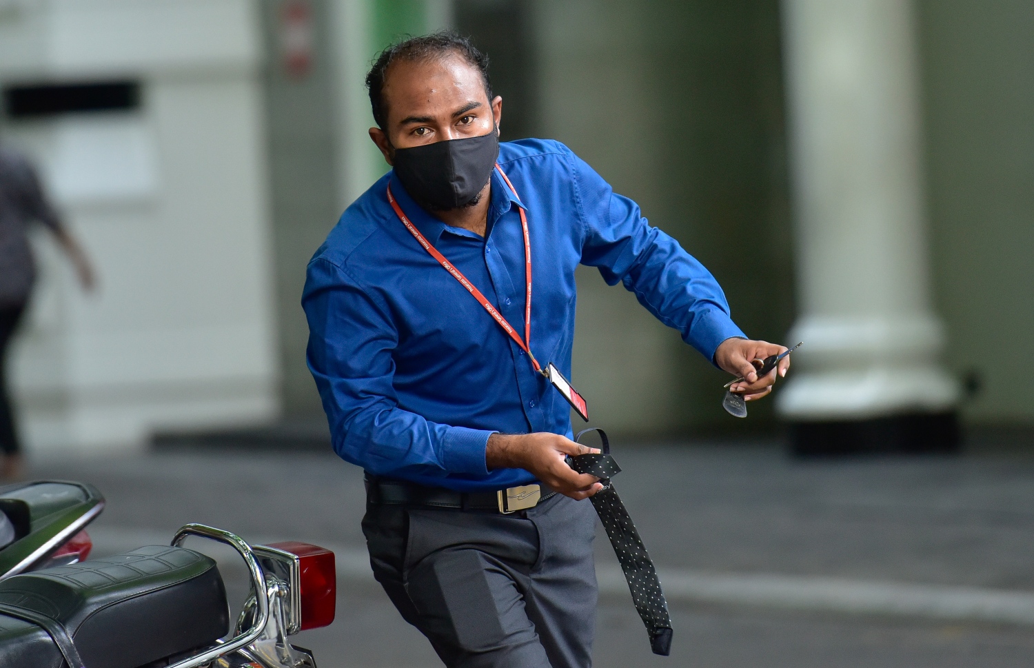 މާލެ: ޖުލައި 5، 2020- އޮފީހުގެ ގަޑި ޖެހޭތީ، މީހަކު ސައިކަލް ޕާކް ކުރުމަށް ފަހު، ޓައި އަތުން ހިފައިގެން ވެލާނާގޭ ބިލްޑިންގަށް ވަންނަން ދުއްވައި ގަންނަނަނީ: ތިން މަހަށް ފަހު ސަރުކާރުގެ އޮފީސްތައް މިއަދުން ފެށިގެން ވަނީ ހުޅުވާފައި.---ފޮޓޯ: އަހުމަދު އަވްޝަން/މިހާރު