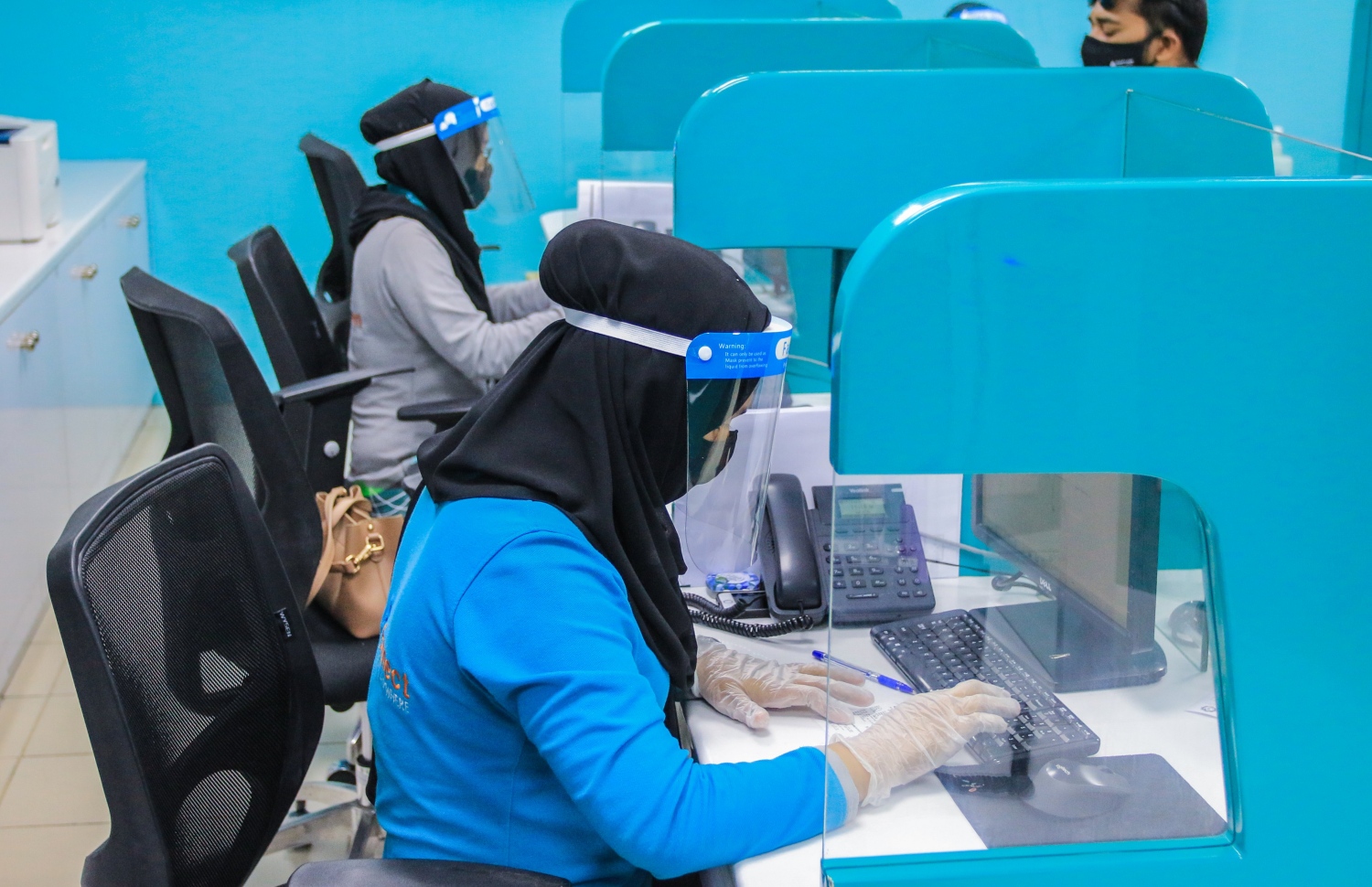 މާލެ: ޖުލައި 5، 2020- ކޮވިޑް-19 އިން ރައްކާތެރިވުމުގެ ފިޔަވަޅުތަކަށް ދިން ލުޔާ އެކު، ސަރުކާރުގެ އޮފީސްތައް މިއަދު ހުޅުވުމުން, މީރާގެ މުވައްޒަފުން މާސްކު، އަންގި އަދި ފޭސް ޝީލްޑާއެކު މަސައްކަތް ކުރަނީ.---ފޮޓޯ: މީރާ