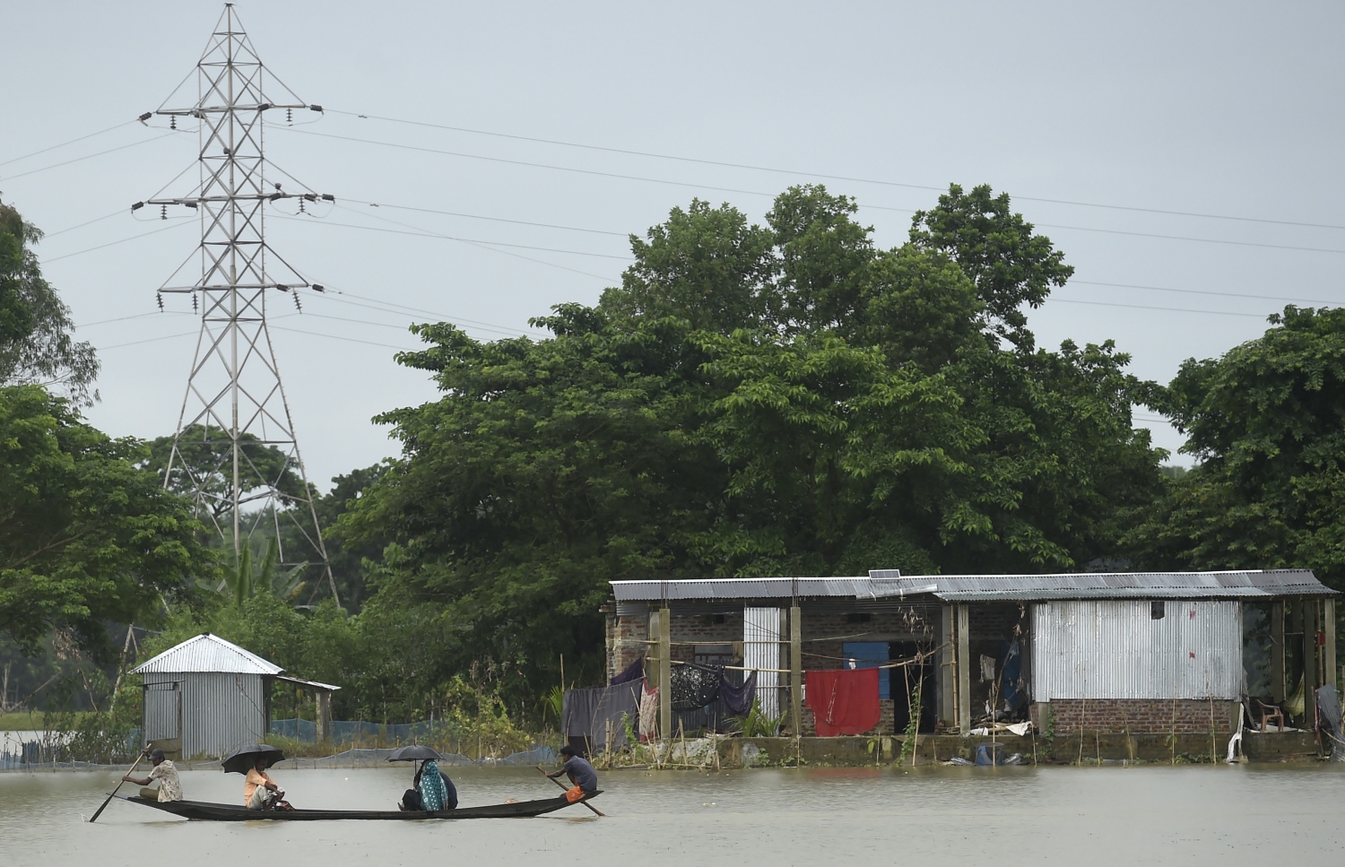 ބަންގްލަދޭޝްގެ ފެންބޮޑުވެފައިވާ ސަރަހައްދެއްގައި ބަޔަކު ޑިންގީއެއްގައި ދަތުރުކުރަނީ. --ފޮޓޯ:އޭއެފްޕީ