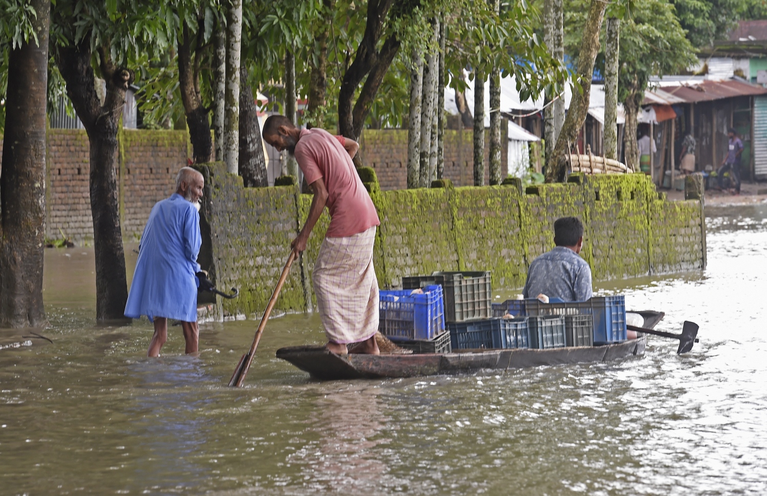 ބަންގްލަދޭޝްގެ ފެންބޮޑުވެފައިވާ ސަރަހައްދެއްގައި މުދާތައް ހިފައިގެން ބަޔަކު ޑިންގީއެއްގައި ދަތުރު ކުރަނީ. --ފޮޓޯ:އޭއެފްޕީ