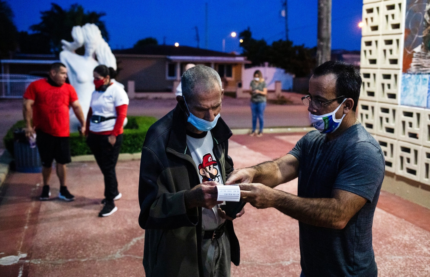 ނޮވެމްބަރު 3، 2020: އެމެރިކާގެ ފްލޮރިޑާގެ މީހަކު ވޯޓު ލާން ޖެހޭ ސެންޓަރު، އިންތިހާބުގެ އޮފިޝަލަކު ކިޔައިދެނީ: އެމެރިކާގައި މިއަދު ވޯޓު ލަނީ ފަހުގެ ތާރީހެއްގައި ފެނިފައިނުވާ ވަރުގެ ވާދަވެރި އިންތިހާބެއްގައި