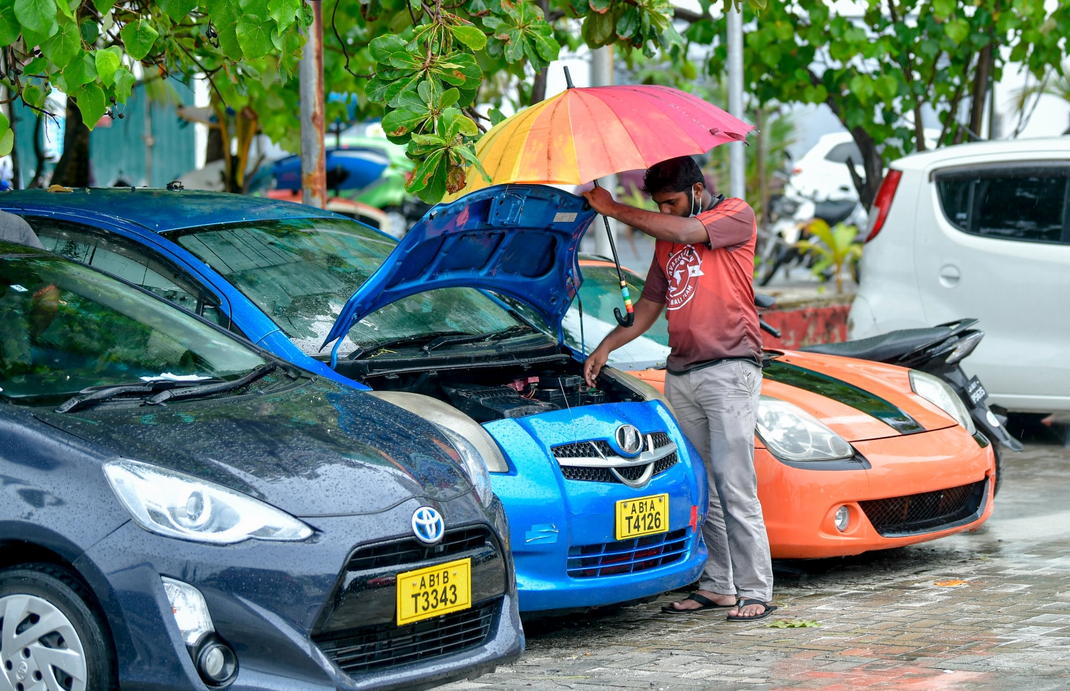 މާލެ: ނޮވެމްބަރު 17، 2020- މާލެ އަށް މިއަދު ވާރޭ ވެހުނު ވަގުތު ވާރެ އިން ހިޔާވުމަށް މީހަކު ކުޑަ އަޅައިގެން ޓެކްސީއެއްގެ ބޮނެޓު ހުޅުވައިގެން އިންޖީނުގެ މަސައްކަތެއް ކުރަނީ: ރޭ 11 ޖަހާކަންހާއިރުން ފެށިގެން މެދުނުކެނޑި ދެ ގަޑިއެއްހާއިރަށް ވެހުނު ބޯ ވާރޭގައި ގިނަ މަގުތަކުގައި ފެންބޮޑުވެ، ދަތިތަކާ ކުރިމަތިވި.---ފޮޓޯ: އަހުމަދު އަވްޝަން/މިހާރު