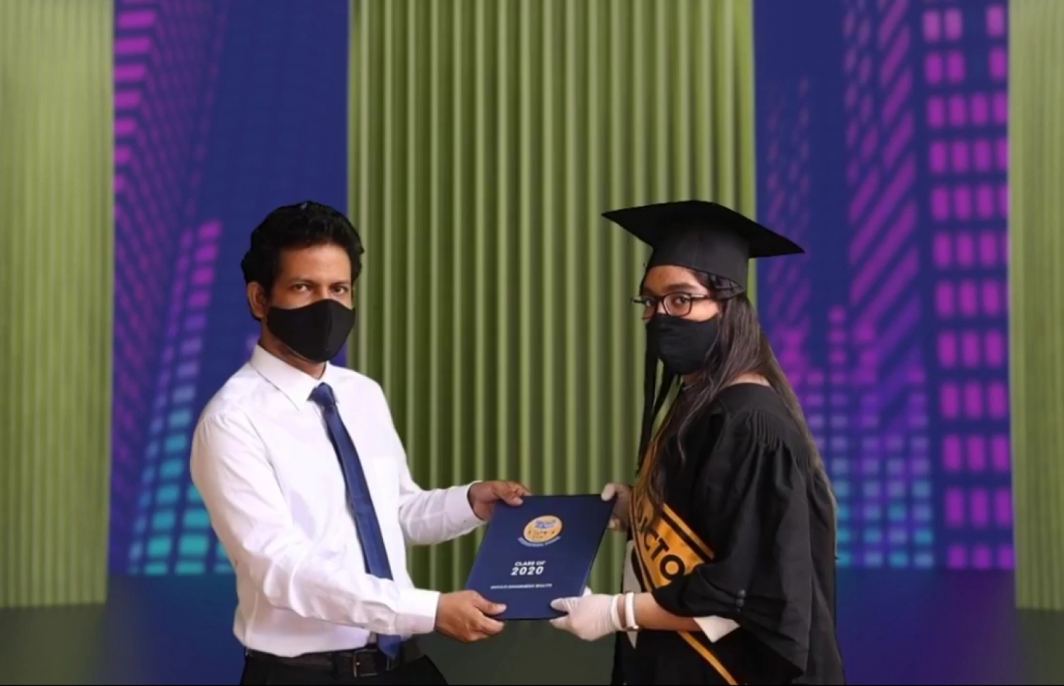 ބިލަބޮންގްގެ ދަރިވަރުން ދަސްވެނިވުމުގެ ރަސްމިއްޔާތުގައި ދަރިވަރަކާ ލިޔުން ހަވާލުކުރައްވަނީ. -- ފޮޓޯ: ބިލަބޮންގް އިންޓަނޭޝަނަލް ހައި ސްކޫލް