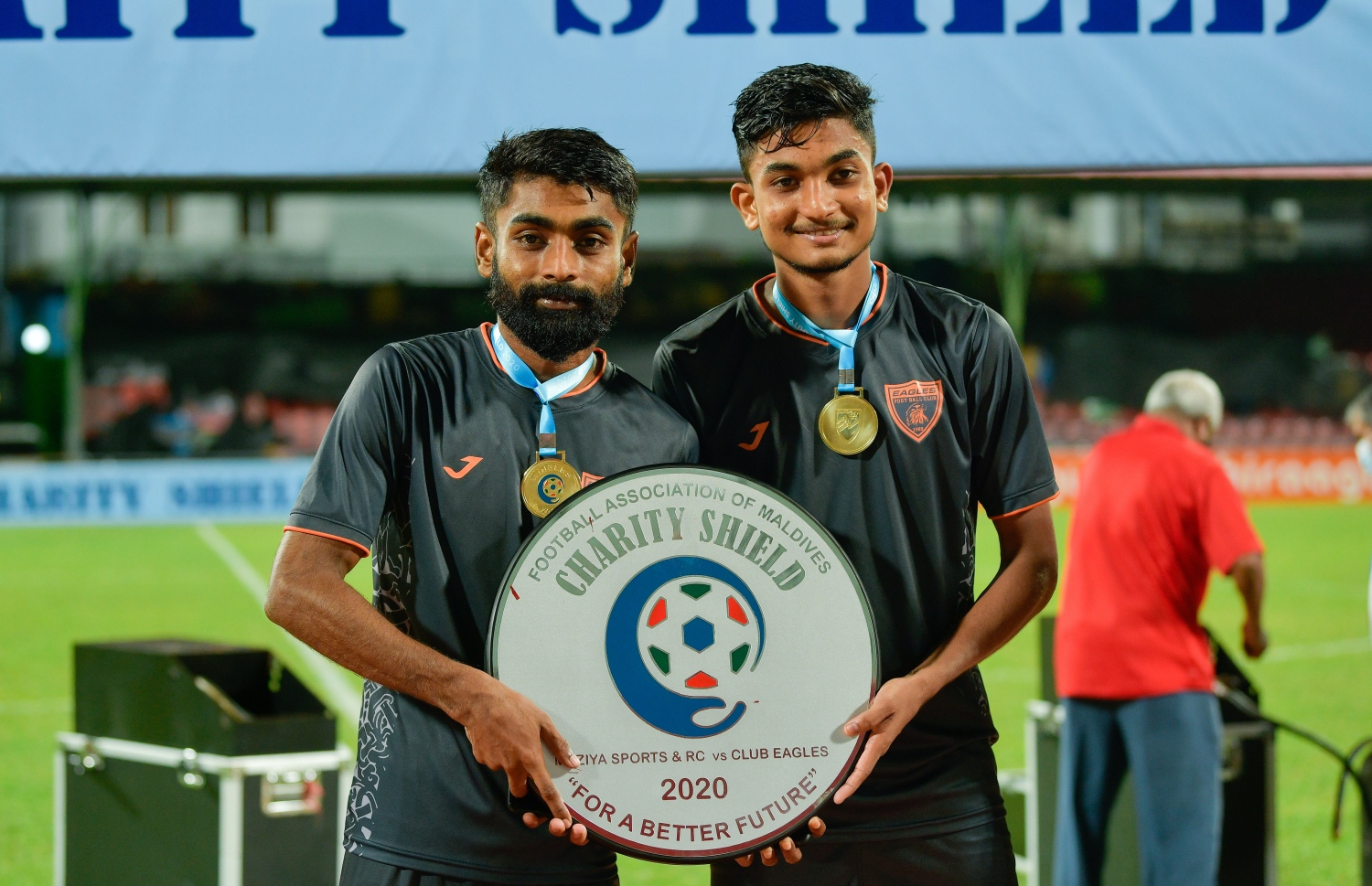 ޒައިން (ކ) އޭނަގެ ބޭބެ ރިޒޭއާ އެކު ޗެރިޓީ ޝީލްޑް ހިފައިގެން.-- ފޮޓޯ: އަހުމަދު އަވްޝަން އިލްޔާސް/ މިހާރު