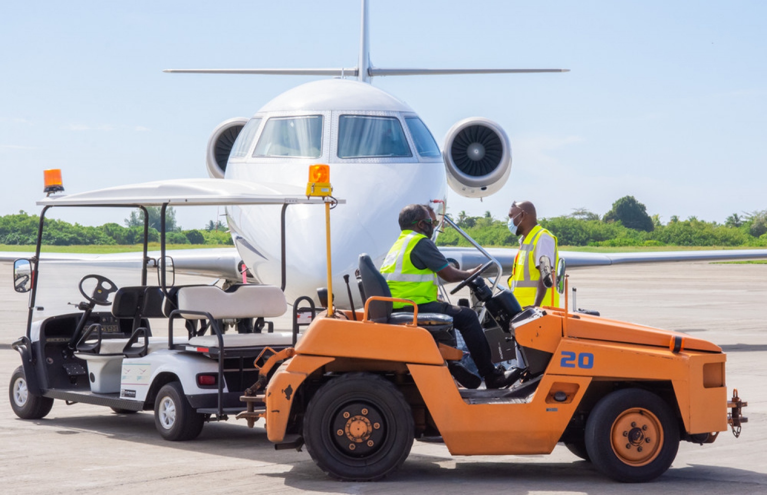 ގަން އެއާޕޯޓްގައި އޮތް ޖެޓެއްގެ ކައިރީގައި އެއާޕޯޓްގެ އޮފިޝަލުންތަކެއް. ފޮޓޯ/ އޭއައިއޭ