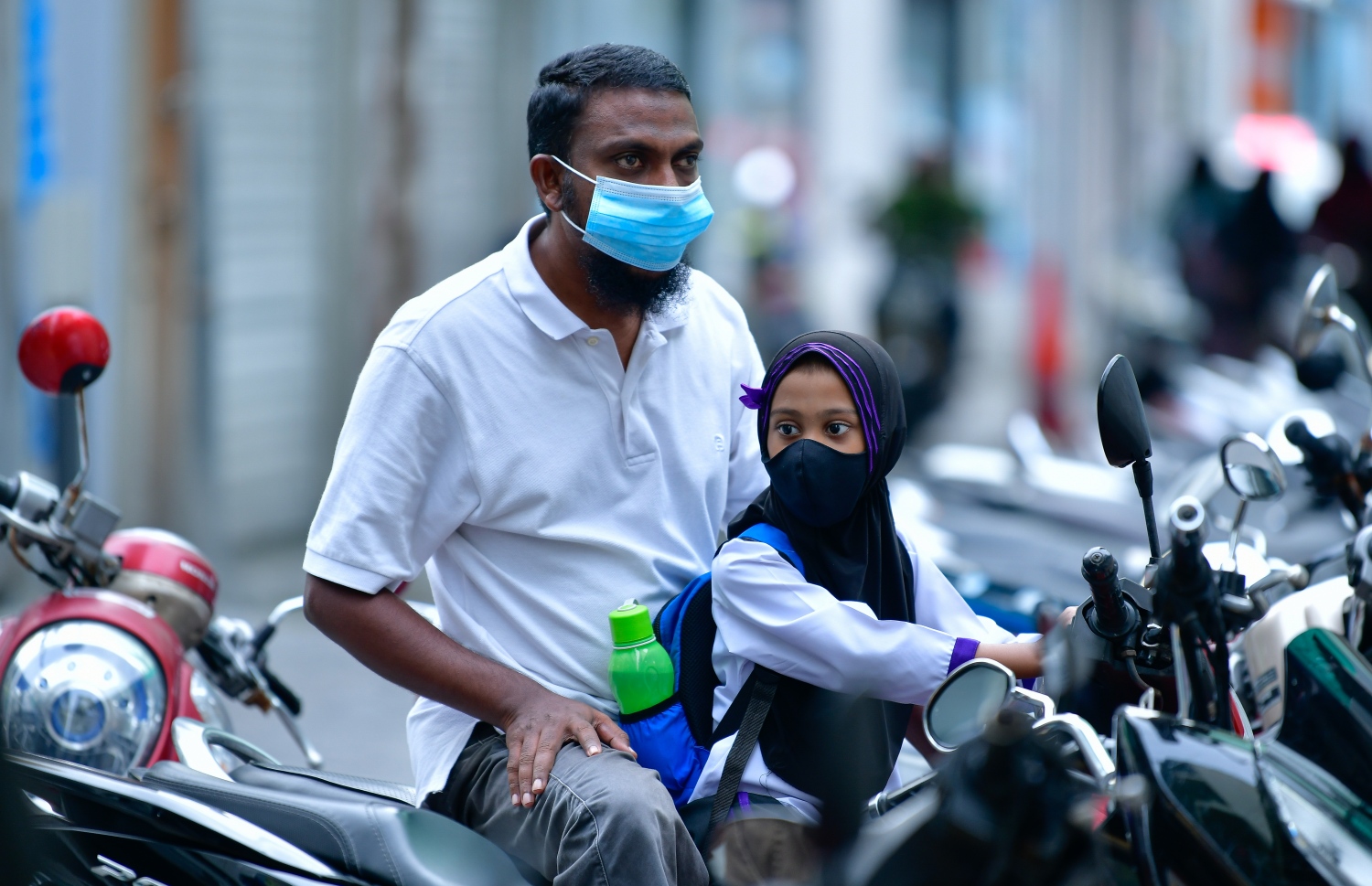 މާލެ- ޖެނުއަރީ 10، 2021- ގާތްގަނޑަކަށް ދޮޅު މަހުގެ ބަންދަކަށް ފަހު ސްކޫލުތައް މިއަދު ހުޅުވުމާއެކު، ދޮންދޫނި ޕްރީ ސްކޫލުގެ ކުއްޖަކު ބެލެނިވެރިޔާއާ އެކު ސައިކަލްގައި މަޑުކޮށްލައިގެން.---ފޮޓޯ: އަހުމަދު އަވްޝަން އިލްޔާސް/މިހާރު