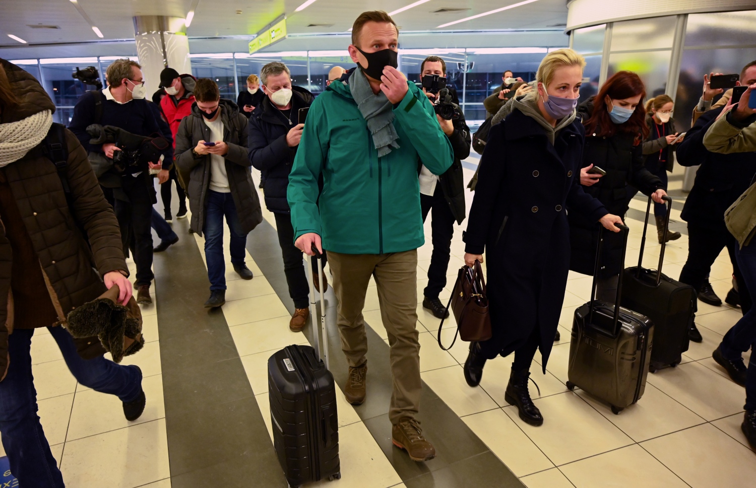 ރަޝިޔާގެ އިދިކޮޅު ލީޑަރު ނަވަލްނީ އާއި އަނބިކަނބަލުން ޔޫލިއާ މޮސްކޯ އެއާޕޯޓުގެ ޕާސްޕޯޓް ކައުންޓަރަށް ވަޑައިގަންނަވަނީ. --ފޮޓޯ:އޭއެފްޕީ