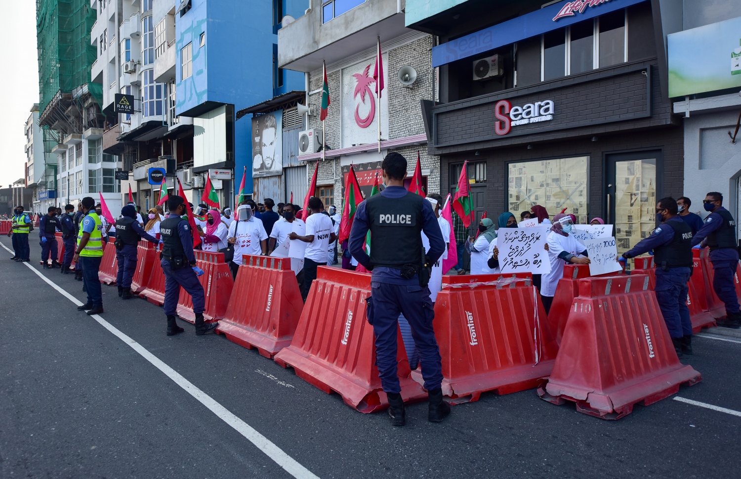 މާލެ: ޖެނުއަރީ 29، 2021- "އިންސާފު ކޮބާ" ގެ ނަމުގައި އިދިކޮޅު ކޯލިޝަނުން ޕީޕީއެމްގެ އޮފީސް ކުރިމައްޗަށް އެއްވެފައިވާއިރު، ފުލުހުން އެ ސަރަހައްދުގައި ބެރިކޭޑު ޖަހައިގެން ބަންދުކޮށްގެން: މާލޭގެ އިތުރުން ރާއްޖޭގެ އެކި ސަރަހައްދުތަކުގައި ވެސް މި މުޒާހަރާތައް ބޭއްވި.---ފޮޓޯ: އަހުމަދު އަވްޝަން/މިހާރު