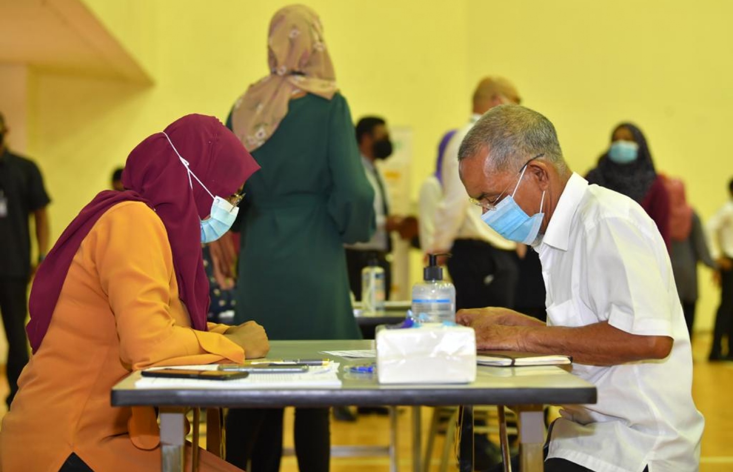 މާލެ: ފެބްރުއަރީ 1، 2021: ރާއްޖޭގައި ކޮވިޑް-19 ވެކްސިން ދިނުމުގެ ޕްރޮގްރާމްގައި ވެކްސިން ދިނުމުގެ ކުރިން ލިޔެކިޔުންތައް ފުރިހަމަ ކުރަނީ.-- ފޮޓޯ: ރައީސް އޮފީސް