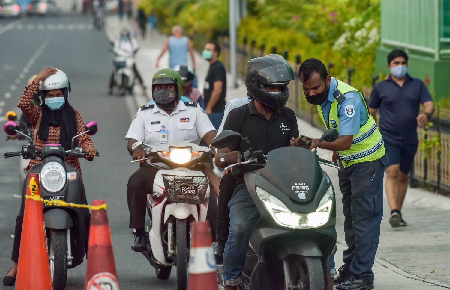 ފެބުރުއަރީ 20، 2021- ކޮވިޑް ޖެހޭ މީހުންގެ އަދަދު ރާއްޖޭގައި އިތުރުވުމާ ގުޅިގެން އެޗުޕީއޭއިން މާލެ ސަރަހައްދުގައި ހަވީރު 6 އިން ހެނދުނު 6 އަށް އެއްގަމު އުޅަނދު ދުއްވުން މަނާ ކުރުމާއެކު ހަވީރު ހައެއް ޖެހުމުގެ ކުރިން ބްރިޖު ހުރަސްކުރާ މީހަކާ ފުލުހަކު ވާހަކަ ދައްކަނީ.--- ފޮޓޯ: ނިޝާން އަލީ/މިހާރު