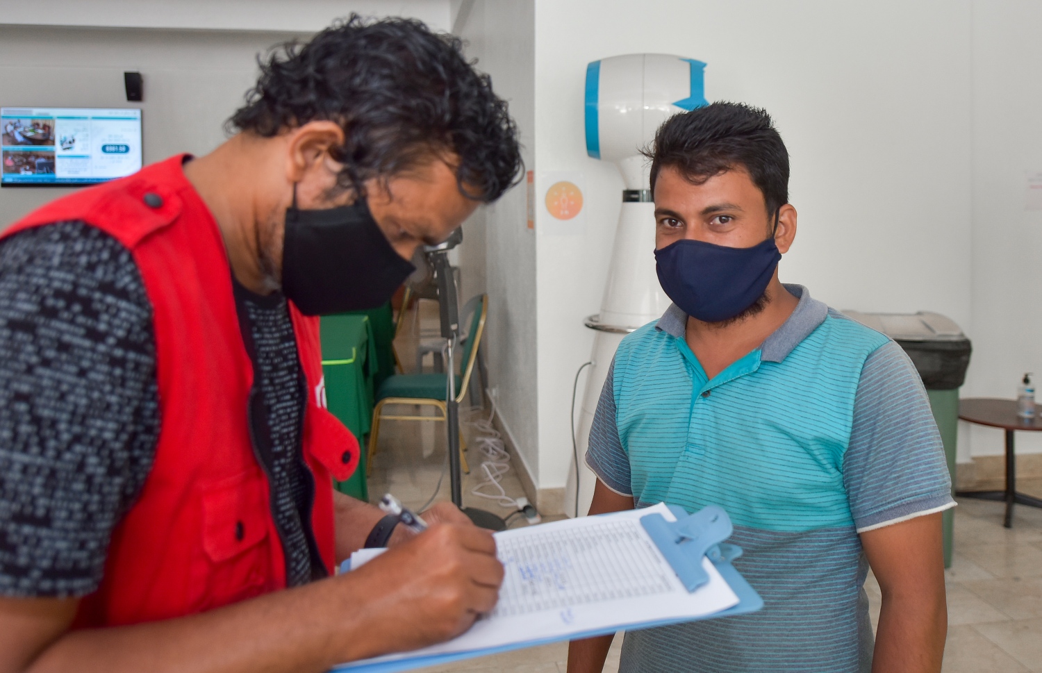 މާލެ: ފެބްރުއަރީ 25، 2021: ގަވައިދާ ހިލާފަށް އުޅޭ ބިދޭސީއެއް ވެކްސިން ޖެހުމުގެ ކުރިން ފުރަންޖެހޭ މައުލޫމާތު ފޯމު ފުރަނީ.-- ފޮޓޯ: އަހުމަދު އަވްޝަން އިލްޔާސް /މިހާރު