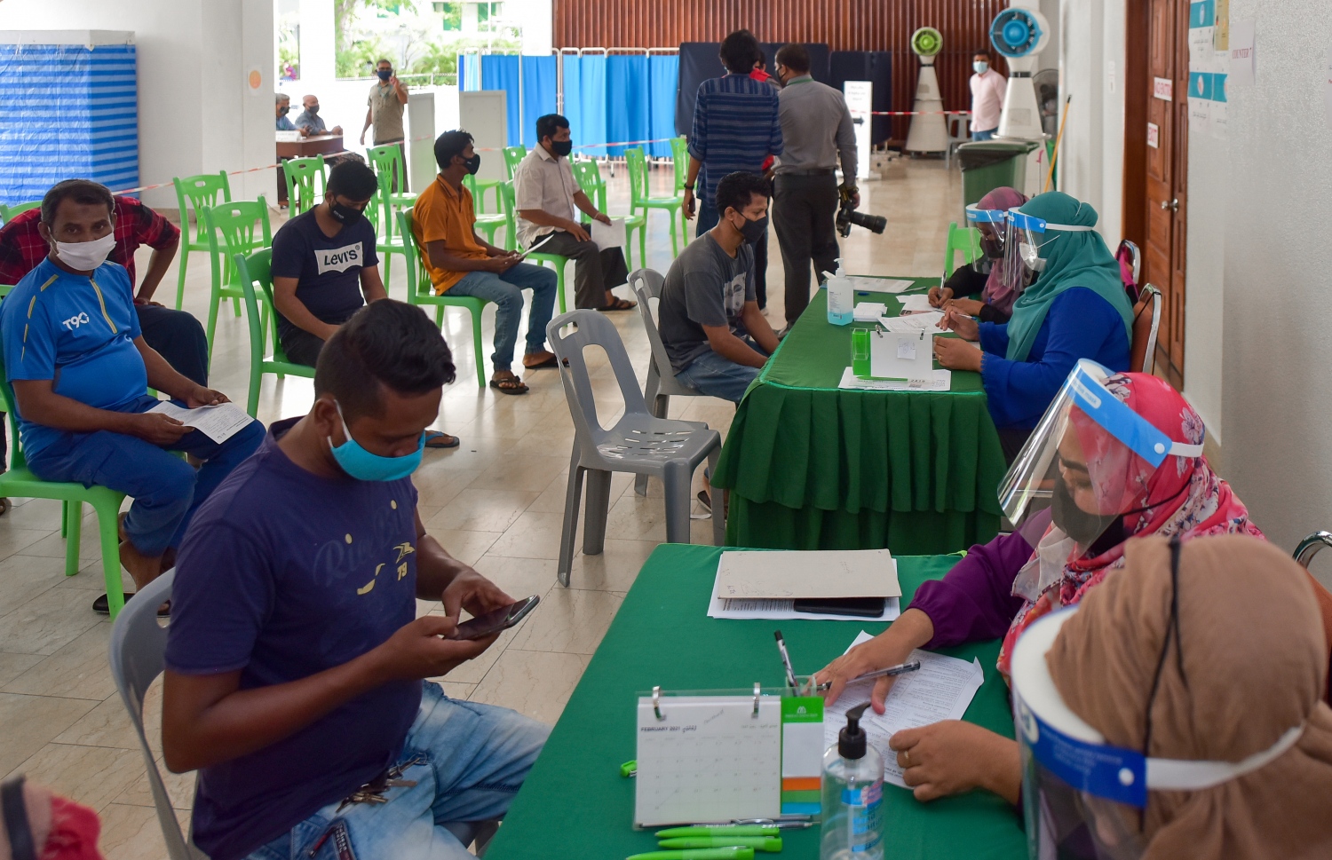 މާލެ: ފެބްރުއަރީ 25، 2021: ލިޔެކިޔުންނެތް ބިދޭސީއެއް ވެކްސިން ޖެހުމުގެ ކުރިން ފުރަންޖެހޭ މައުލޫމާތު ފޯމު ފުރަނީ.-- ފޮޓޯ: އަހުމަދު އަވްޝަން އިލްޔާސް /މިހާރު