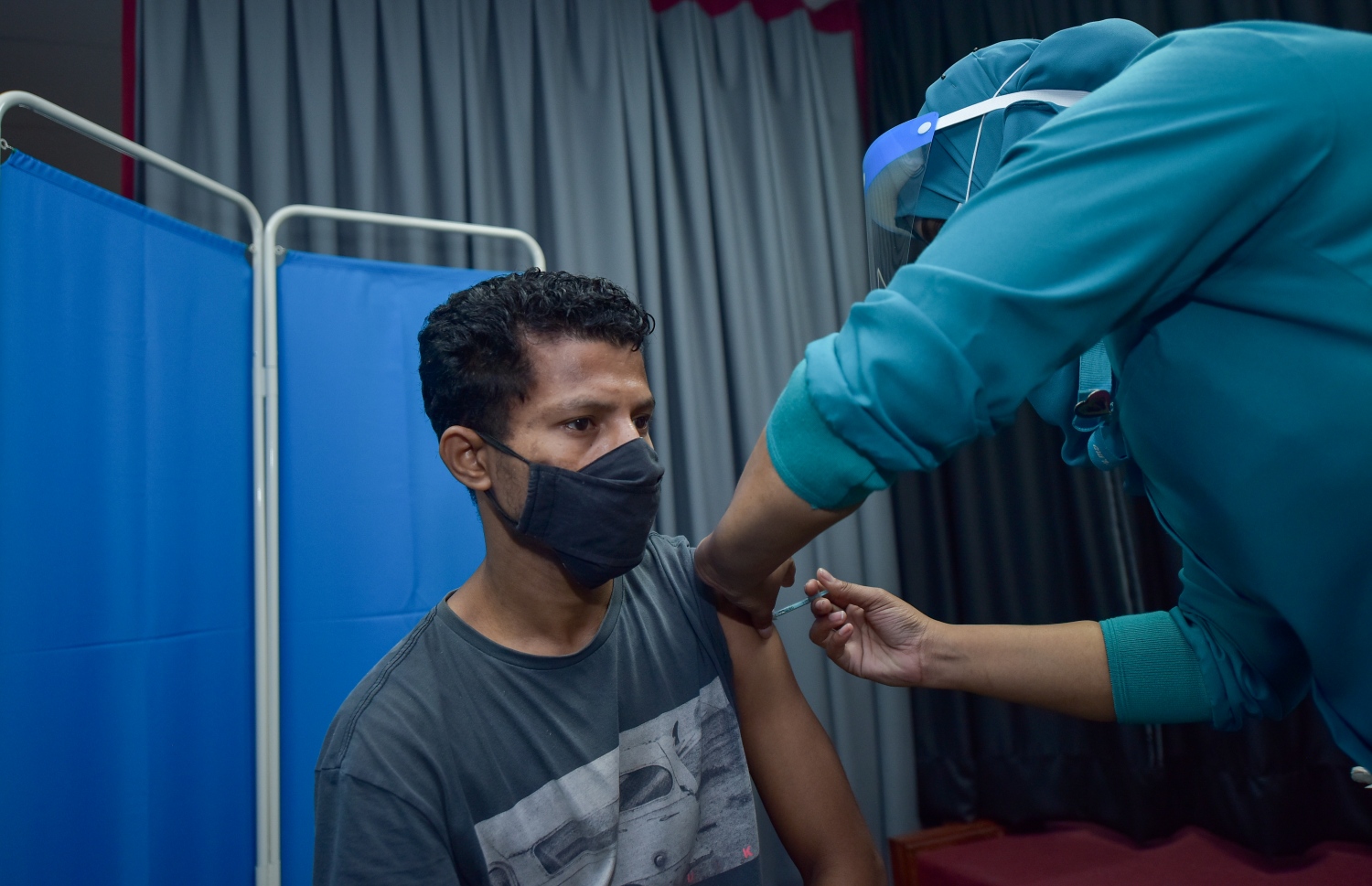 މާލެ: ފެބްރުއަރީ 25، 2021: ލިޔެކިޔުންނެތް ބިދޭސީއަކަށް ވެކްސިން ޖަހަނީ.-- ފޮޓޯ: އަހުމަދު އަވްޝަން އިލްޔާސް /މިހާރު