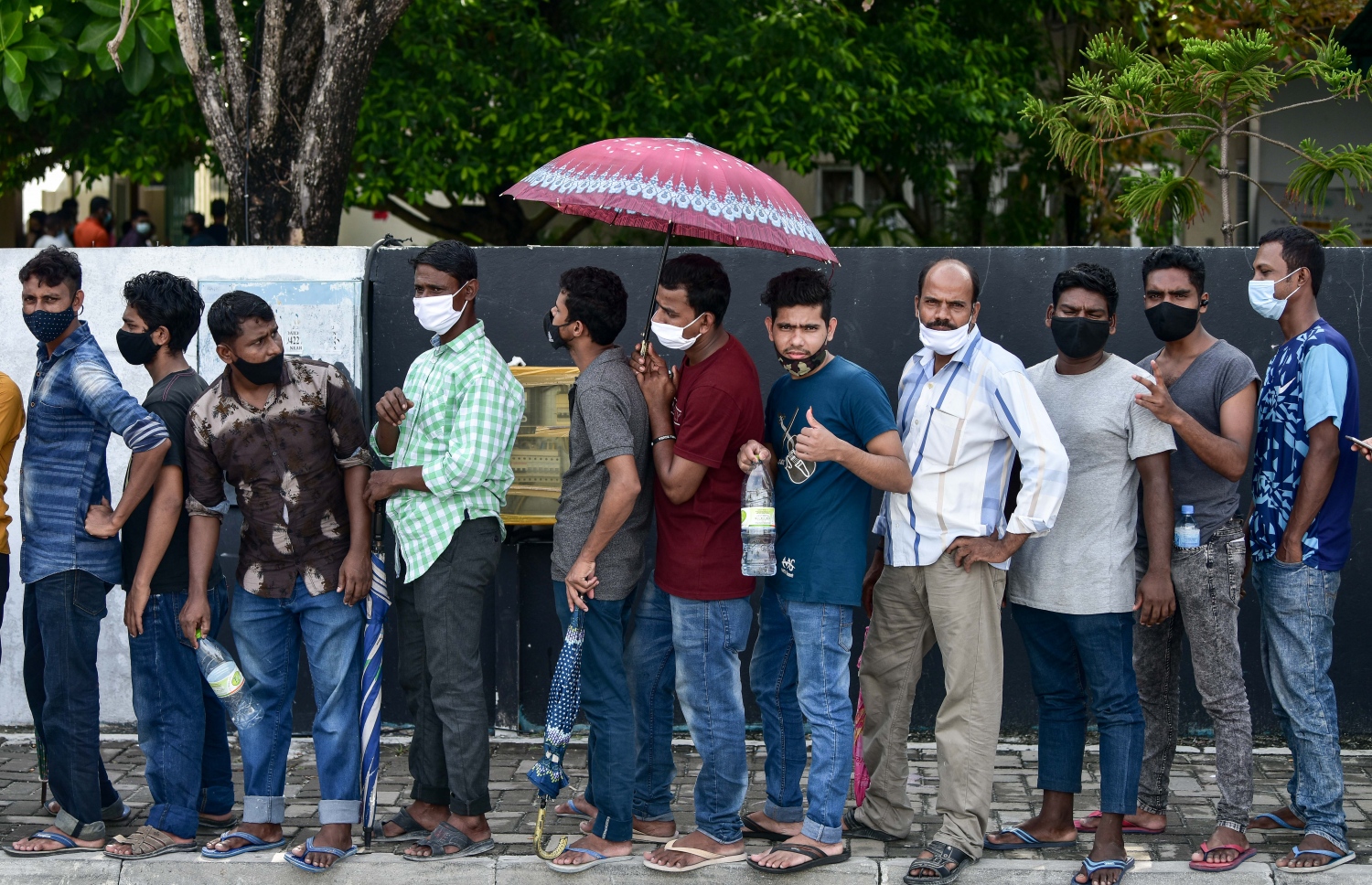 މާލެ- މާޗް 14، 2021: ކޮވިޑް ވެކްސިން ޖަހަން ސޯޝަލް ސެންޓަރު ބޭރުގައި މިއަދު ހެނދުނު އެތައް ސަތޭކަ ބަޔަކު ކިއޫގައި، ވެކްސިންގެ ފުރަތަމަ ޑޯޒް އާންމުކޮށް ޖަހައިދިނުން މާދަމާ ހުއްޓާލާތީ މިއަދުވެސް ވެކްސިން ސެންޓަރުތަކަށް ބާރު ބޮޑުވެ އެތައް ސަތޭކަ ބަަޔަކާ އެކު ކިއޫތައް ވަނީ ދަމާލާފައި--. ފޮޓޯ:ނިޝާން އަލީ/މިހާރު