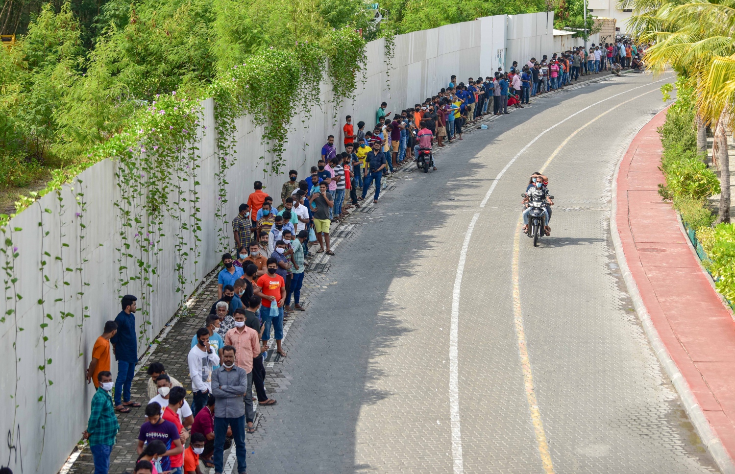 މާލެ- މާޗް 14، 2021: ކޮވިޑް ވެކްސިން ޖަހަން ސޯޝަލް ސެންޓަރު ބޭރުގައި މިއަދު ހެނދުނު އެތައް ސަތޭކަ ބަޔަކު ކިއޫގައި، ވެކްސިންގެ ފުރަތަމަ ޑޯޒް އާންމުކޮށް ޖަހައިދިނުން މާދަމާ ހުއްޓާލާތީ މިއަދުވެސް ވެކްސިން ސެންޓަރުތަކަށް ބާރު ބޮޑުވެ އެތައް ސަތޭކަ ބަަޔަކާ އެކު ކިއޫތައް ވަނީ ދަމާލާފައި--. ފޮޓޯ:ނިޝާން އަލީ/މިހާރު