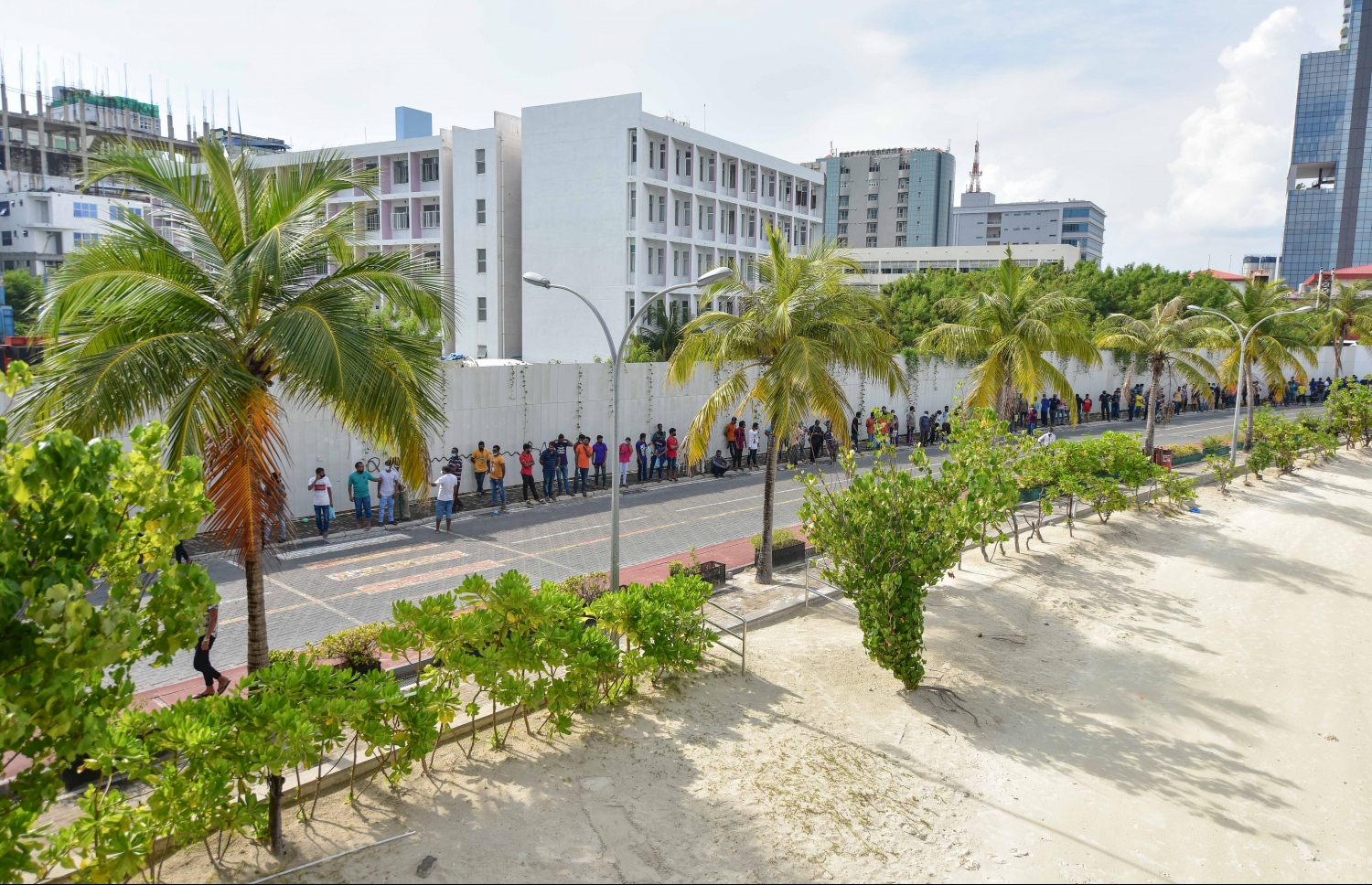 މާލެ- މާޗް 14، 2021: ކޮވިޑް ވެކްސިން ޖަހަން ސޯޝަލް ސެންޓަރު ބޭރުގައި މިއަދު ހެނދުނު އެތައް ސަތޭކަ ބަޔަކު ކިއޫގައި، ވެކްސިންގެ ފުރަތަމަ ޑޯޒް އާންމުކޮށް ޖަހައިދިނުން މާދަމާ ހުއްޓާލާތީ މިއަދުވެސް ވެކްސިން ސެންޓަރުތަކަށް ބާރު ބޮޑުވެ އެތައް ސަތޭކަ ބަަޔަކާ އެކު ކިއޫތައް ވަނީ ދަމާލާފައި--. ފޮޓޯ:ނިޝާން އަލީ/މިހާރު