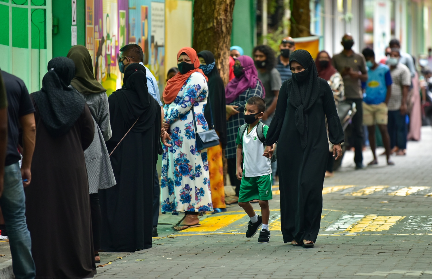 މަހަކަށް ވުރެ ގިނަ ދުވަހަށް ފަހު މާލެ ސަރަހައްދުގެ ދަށް ގްރޭޑުތަކަށް ސްކޫލުތައް ހުޅުވާލުމުން، ބެލެނިވެރިއަކު ދަރިވަރަކު ގޮވައިގެން ސްކޫލަށް ދަނީ.-- ފޮޓޯ: އަހުމަދު އަވްޝަން/ މިހާރު