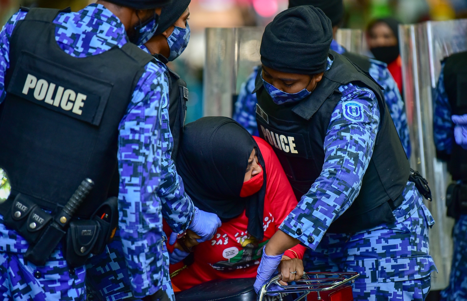 މާލެ، އޭޕްރީލް 2، 2021- އިދިކޮޅު ޕީޕީއެމް/ޕީއެންސީން މާލޭގައި މިއަދު ކުރި މުޒާހަރާގެ ތެރެއިން އަންހެނަކު ފުުލުހުންގެ ވެހިކަލަކަށް އަރުވަން މަސައްކަތް ކުރަނީ: މިއަދުގެ މުޒާހަރާގައި ވަނީ ކުޑަކުދިންނަށް ކުރާ ޖިންސީ އަނިޔާ އާއި ރޭޕްކުރުމާ ދެކޮޅަށް ސަރުކާރުން އެކަށީގެންވާ ފިޔަވަލުތައް ނާޅާ ކަމަށް ބުނެ އެކަން ބަދަލުކުރުމަށް އަޑު އުފުލާފައި.---ފޮޓޯ: އަހުމަދު އަވްޝަން/މިހާރު