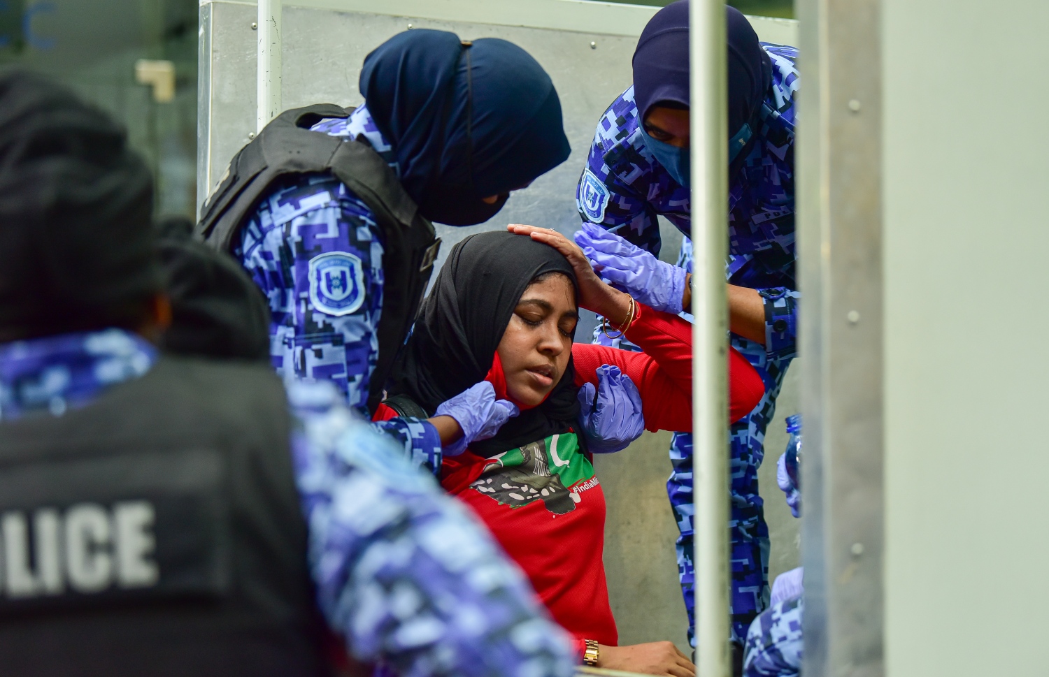 މާލެ، އޭޕްރީލް 2، 2021- އިދިކޮޅު ޕީޕީއެމް/ޕީއެންސީން މާލޭގައި މިއަދު ކުރި މުޒާހަރާގެ ތެރެއިން އަންހެނަކު ފުުލުހުންގެ ވެހިކަލަކަށް އަރުވާފައިވާއިރު އޭނާގެ ކައިރީގައި އަންހެން ދެ ފުލުހަކު މަޑުކޮށްލައިގެން: މިއަދުގެ މުޒާހަރާގައި ވަނީ ކުޑަކުދިންނަށް ކުރާ ޖިންސީ އަނިޔާ އާއި ރޭޕްކުރުމާ ދެކޮޅަށް ސަރުކާރުން އެކަށީގެންވާ ފިޔަވަލުތައް ނާޅާ ކަމަށް ބުނެ އެކަން ބަދަލުކުރުމަށް އަޑު އުފުލާފައި.---ފޮޓޯ: އަހުމަދު އަވްޝަން/މިހާރު