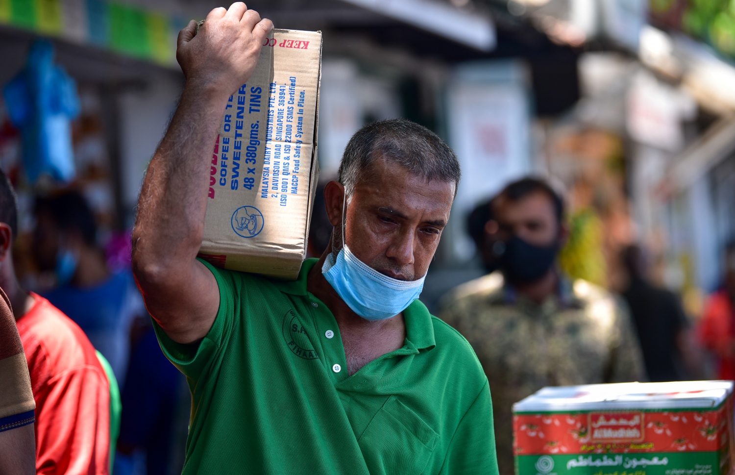 ރަށަކަށް ގެންދާ ފޮށިގަނޑެއް ލައިގެން މީހަކު ދަނީ: މާލޭގެ ބާޒާރުމަތި މި ދުވަސްވަރު ވަރަށް ބާރުބޮޑު. އަންނަ ހަފުތާގައި ރޯދަ މަސް ފަށާތީ ގިނަ އަދަދެއްގެ ދޯނިފަހަރު މިހާރު އޮތީ މާލޭ ފަޅުގައި -- ފޮޓޯ: އަހުމަދު އަވްޝަން/ މިހާރު