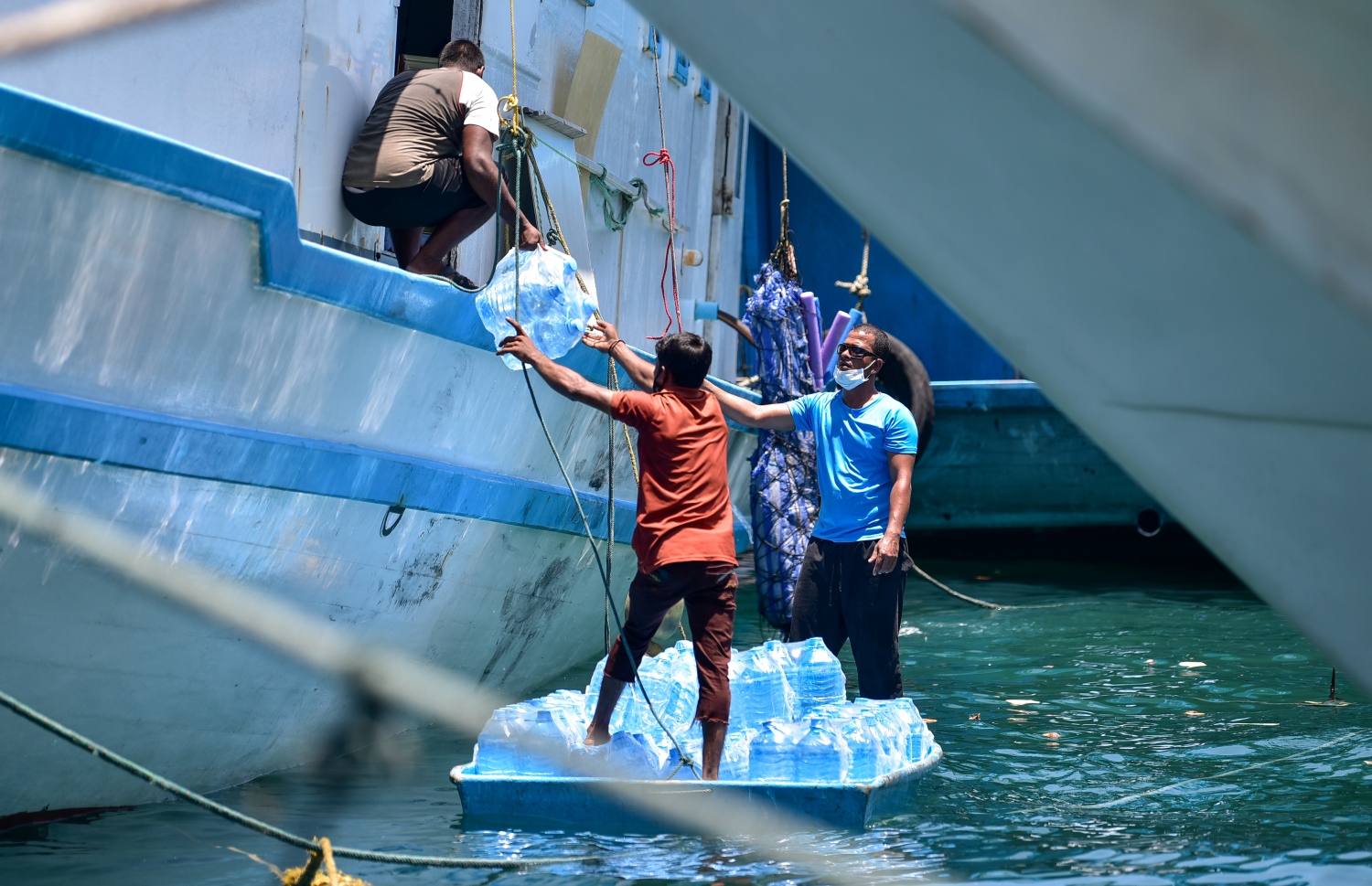 ރަށަކަށް ގެންދާ ފެންކޭސްތަކެއް މީހަކު ބޯޓަކަށް އަރުވަނީ: އަންނަ ހަފުތާގެ މެދުތެރޭގައި ރޯދަ މަސް ފަށާއިރު ވަރަށް ގިނަ ރަށްރަށަށް މިހާރު ވަނީ މުދާ ގެންދަން ފަށައިފައި -- ފޮޓޯ: އަހުމަދު އަވްޝަން/ މިހާރު