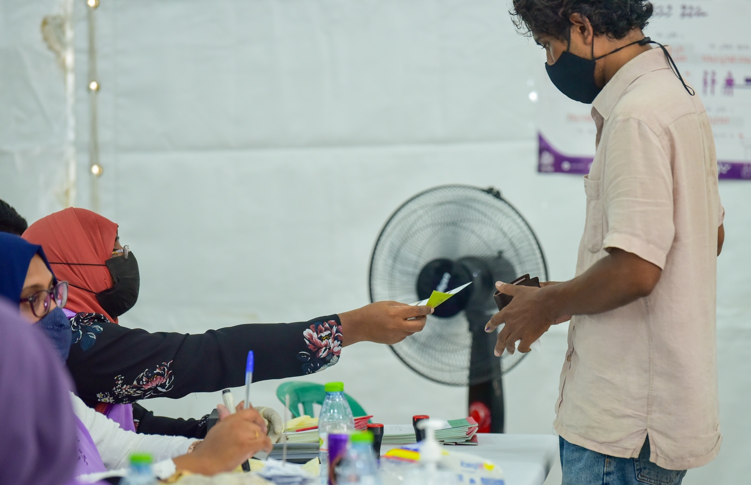 އިންތިހާބެއްގައި ވޯޓު ލުމަށް މީހަކަށް އޮފިޝަލުން ވޯޓު ކަރުދާސް ހަވާލުކުރަނީ. -- މިހާރު ފައިލް ފޮޓޯ