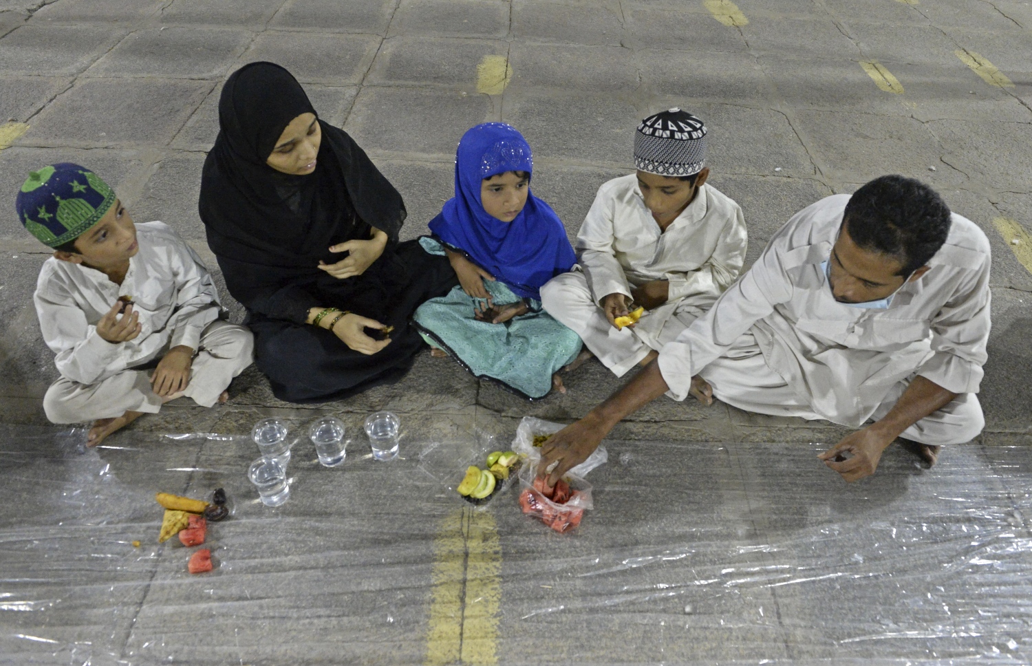 މައްކާ: އޭޕްރިލް 16، 2021: މައްކާގެ މިސްކިތެއްގައި އާއިލާއެއް، ރޯދަ މަހުގެ ފުރަތަމަ ހުކުރު ދުވަހުގެ ރޯދަ ވީއްލަނީ.-- ފޮޓޯ: އޭއެފްޕީ