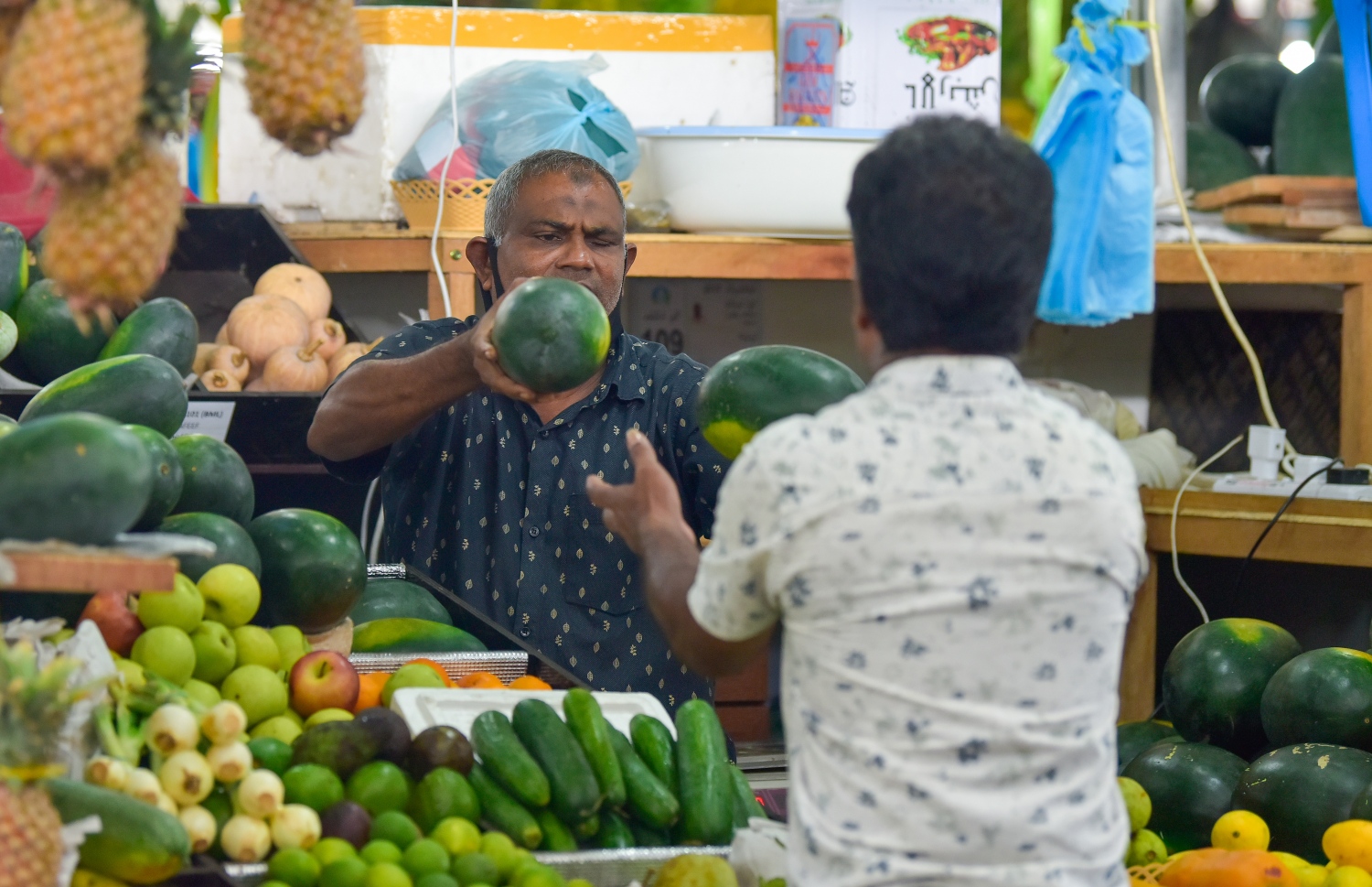 މާރުކޭޓުގައި މީހަކު ކަރާ ގަންނަނީ: ކަރާގެ އަގު ވެސް ވަނީ ދަށްވެފައި-- ފޮޓޯ: އަހުމަދު އަވްޝަން/ މިހާރު