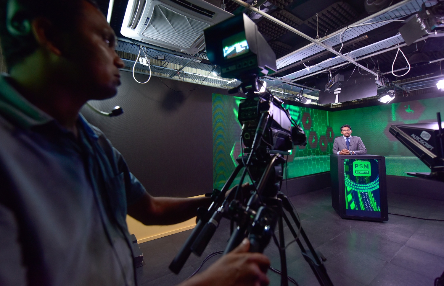 މާލެ: މޭ 3، 2021: ޕީއެސްއެމްގެ ނޫސްވެރިއަކު ހަބަރު ކިޔަމުންދާއިރު، ވީޑިއޯގްރަފަރު ވީޑިއޯ ކުރަނީ.-- ފޮޓޯ: އަވްޝަން  އިލްޔާސް /މިހާރު