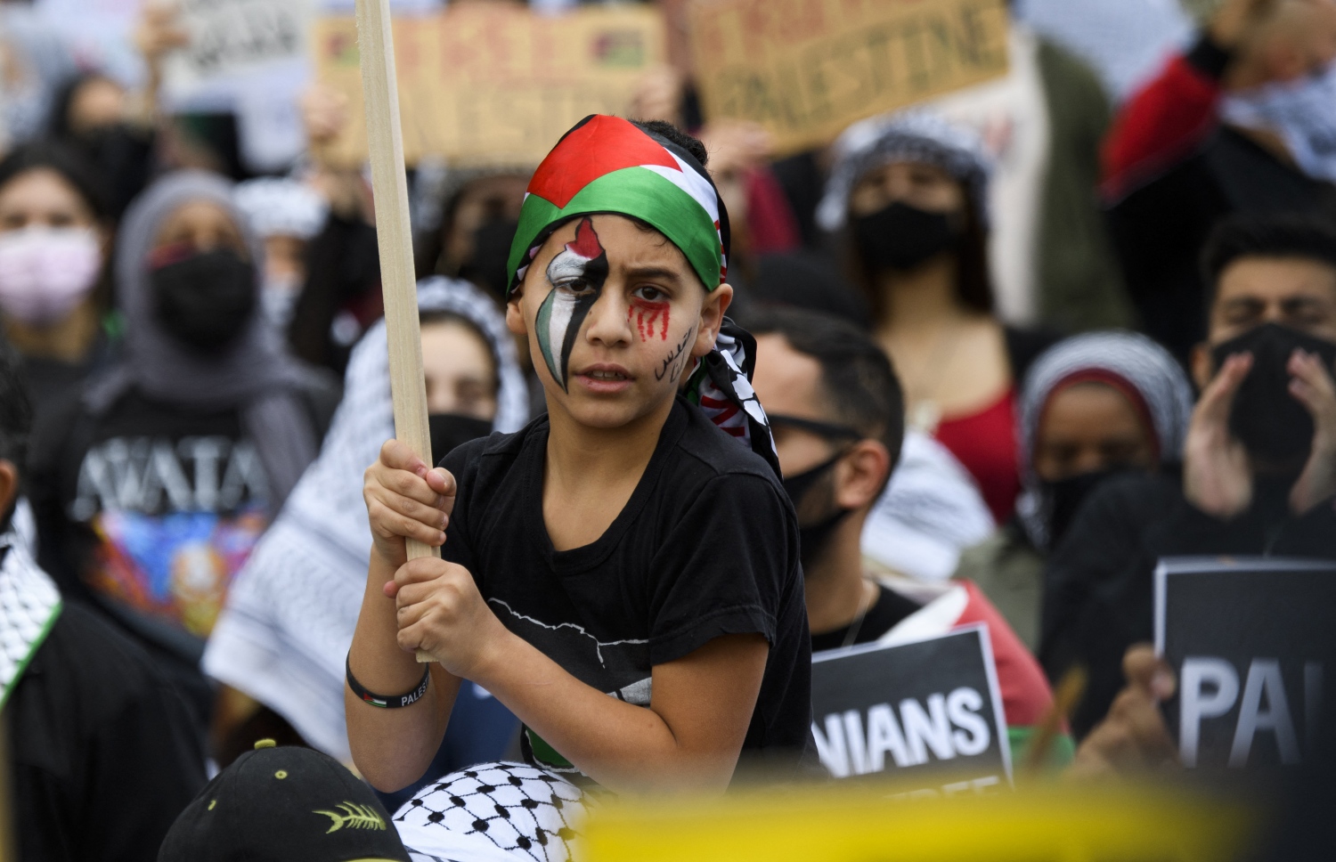 ލޮސް އެޖެލިސް: މޭ 16، 2021: އިޒްރޭލުން ގާޒާއަށް ދެމުންދާ ބޮމުގެ ހަމަލާ އާއި ދެކޮޅަށް ފަލަސްތީނުގެ ރައްޔިތުން ކުރާ މުޒާހަރާގައި ބައިވެރިވެ، ފަލަސްތީނަށް ސަޕޯޓުކުރުމުގެ ގޮތުން ކުއްޖަކު މޫނުގައި ފަލަސްތީނުގެ ދިދަ ކުރަހާފައި.-- ފޮޓޯ: އޭއެފްޕީ